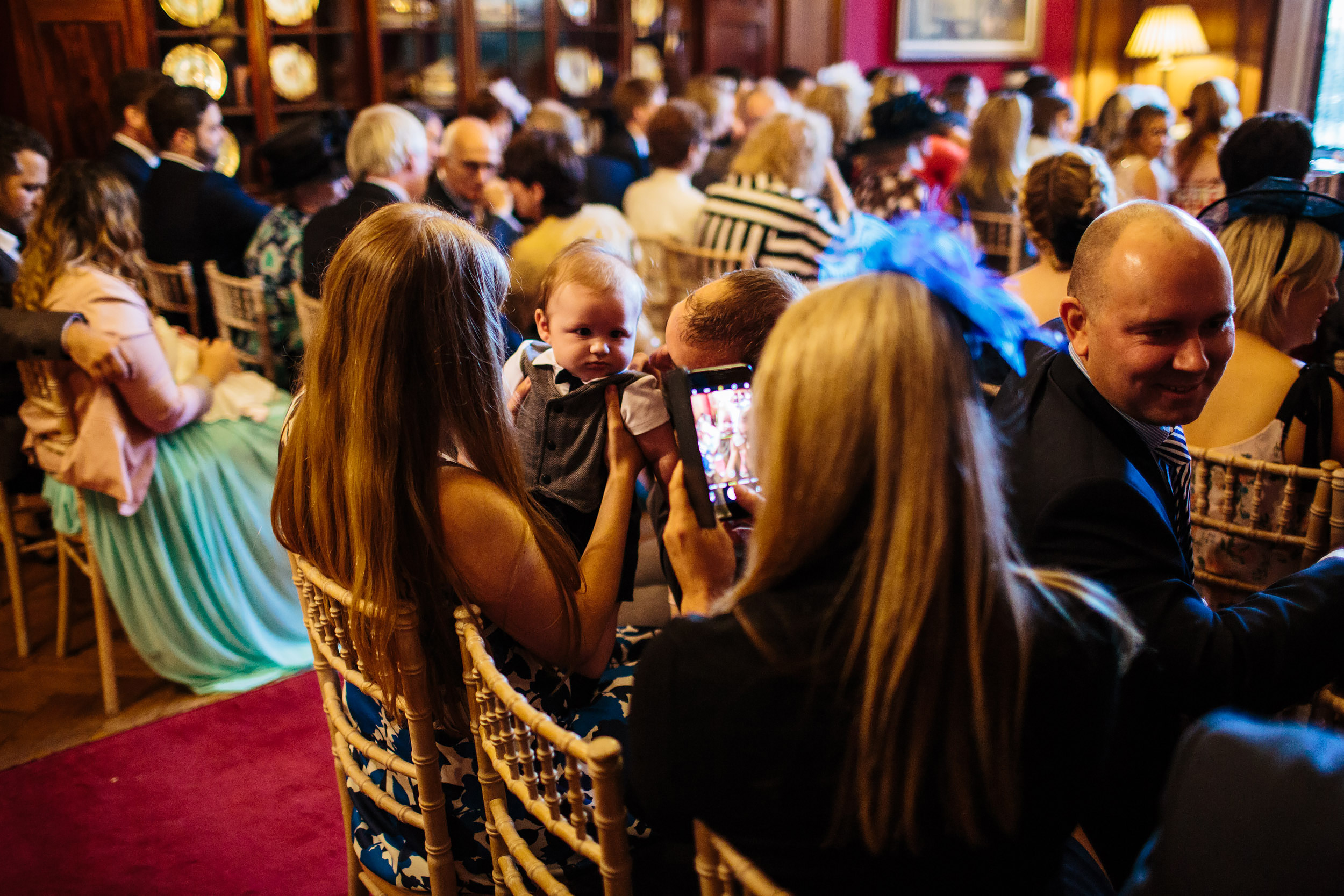 Wedding guests take photo of a baby at Thornton Manor Cheshire