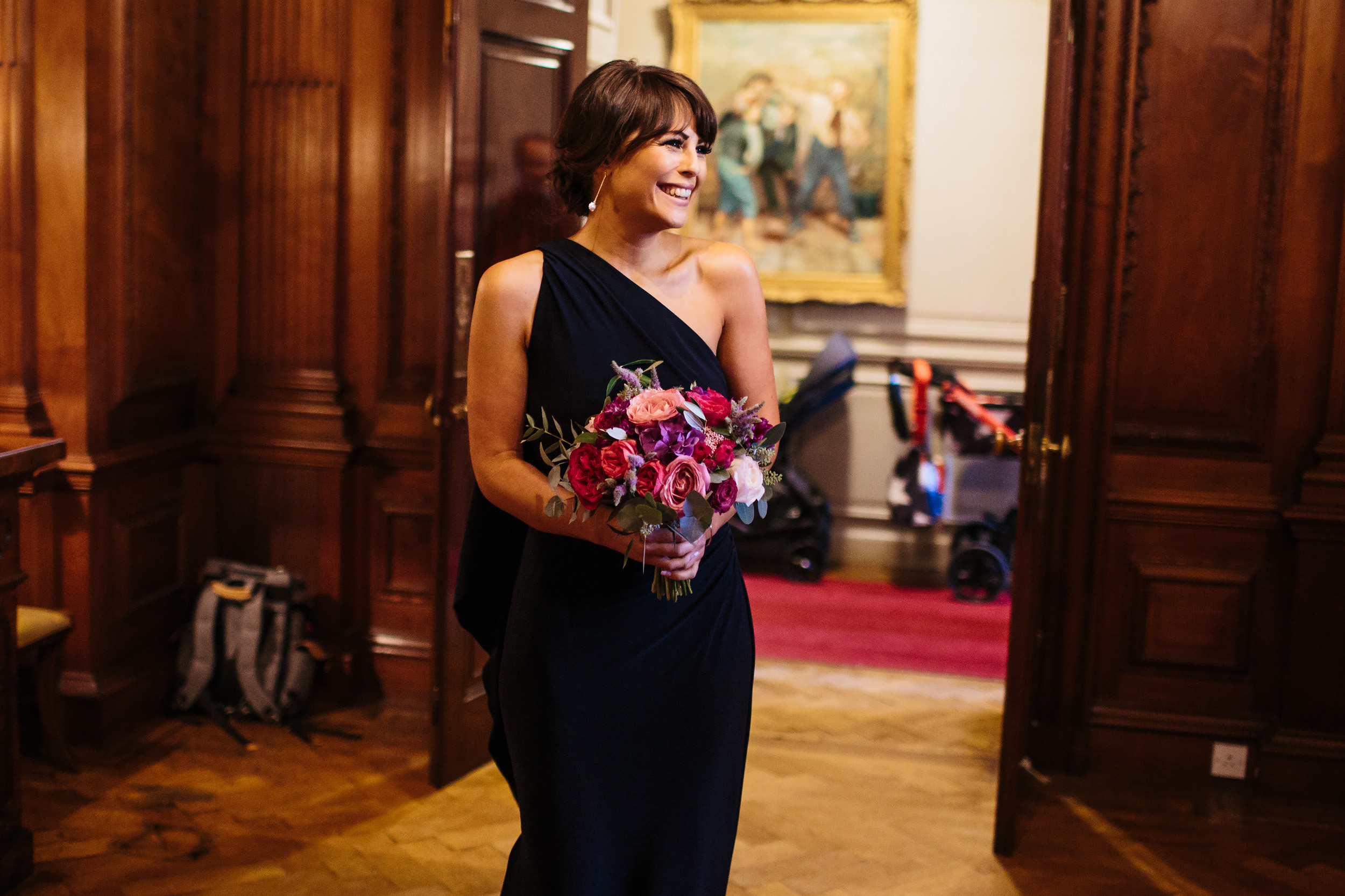 Bride of honour enters wedding reception holding her bouquet