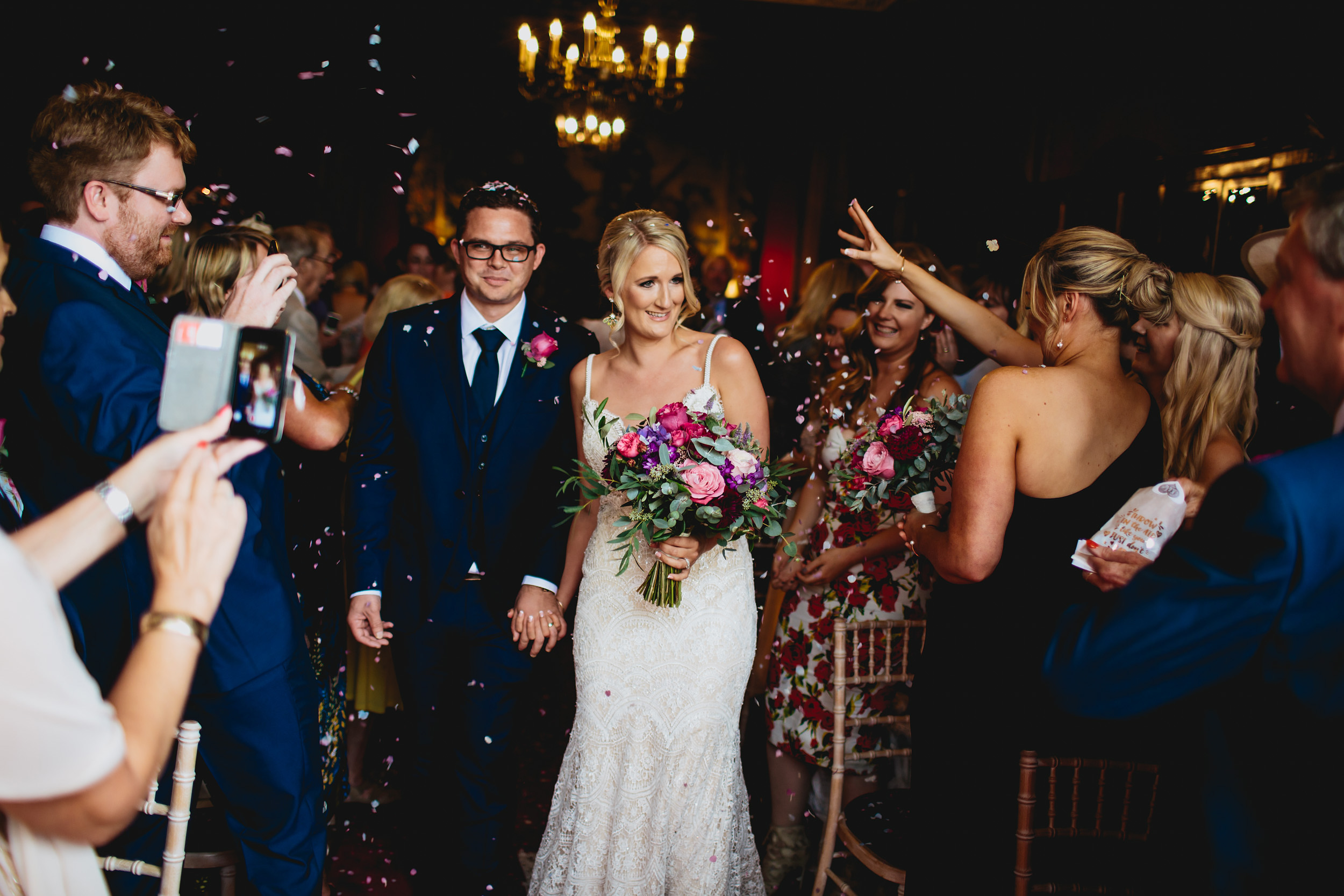 Guests throw confetti over the bride and groom at a wedding