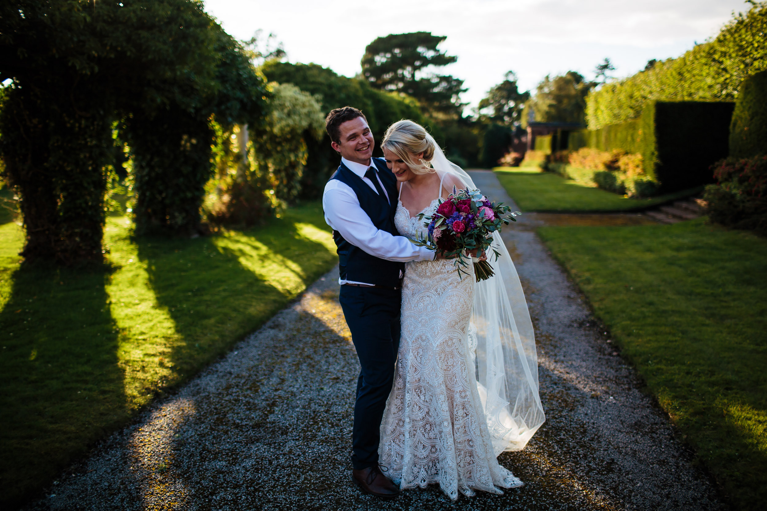 Bride and groom laughing in the gardens at Thornton Manor Cheshire