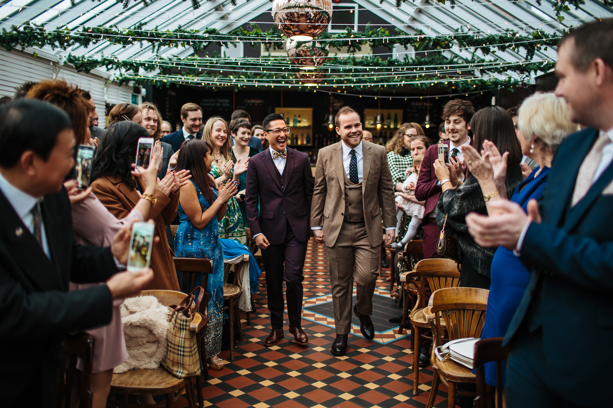 Grooms smiling as they walk down the aisle in Yorkshire
