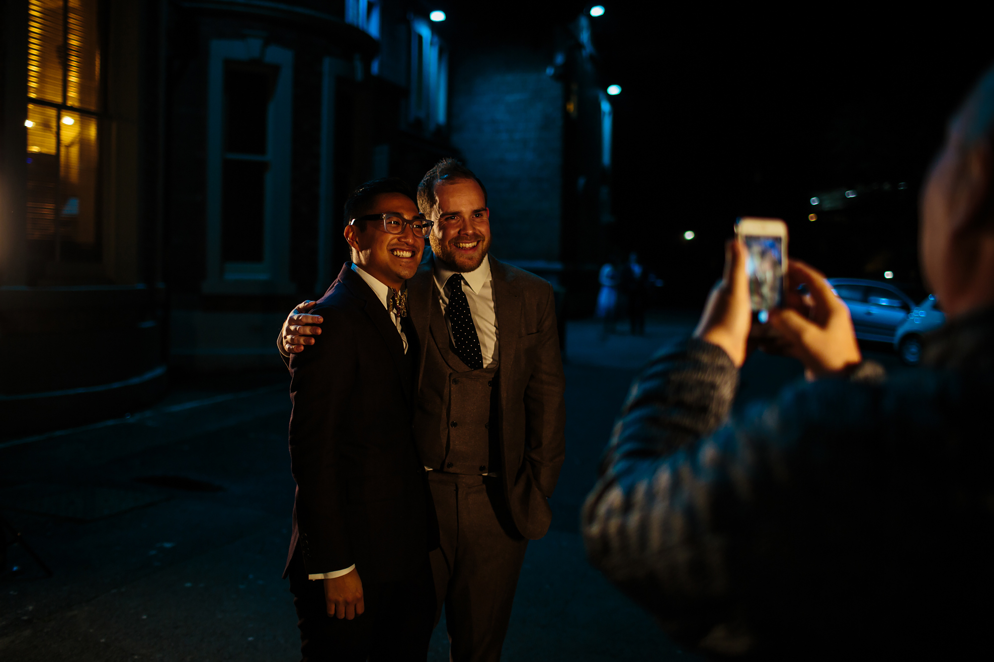 Grooms pose for a photo at a gay wedding