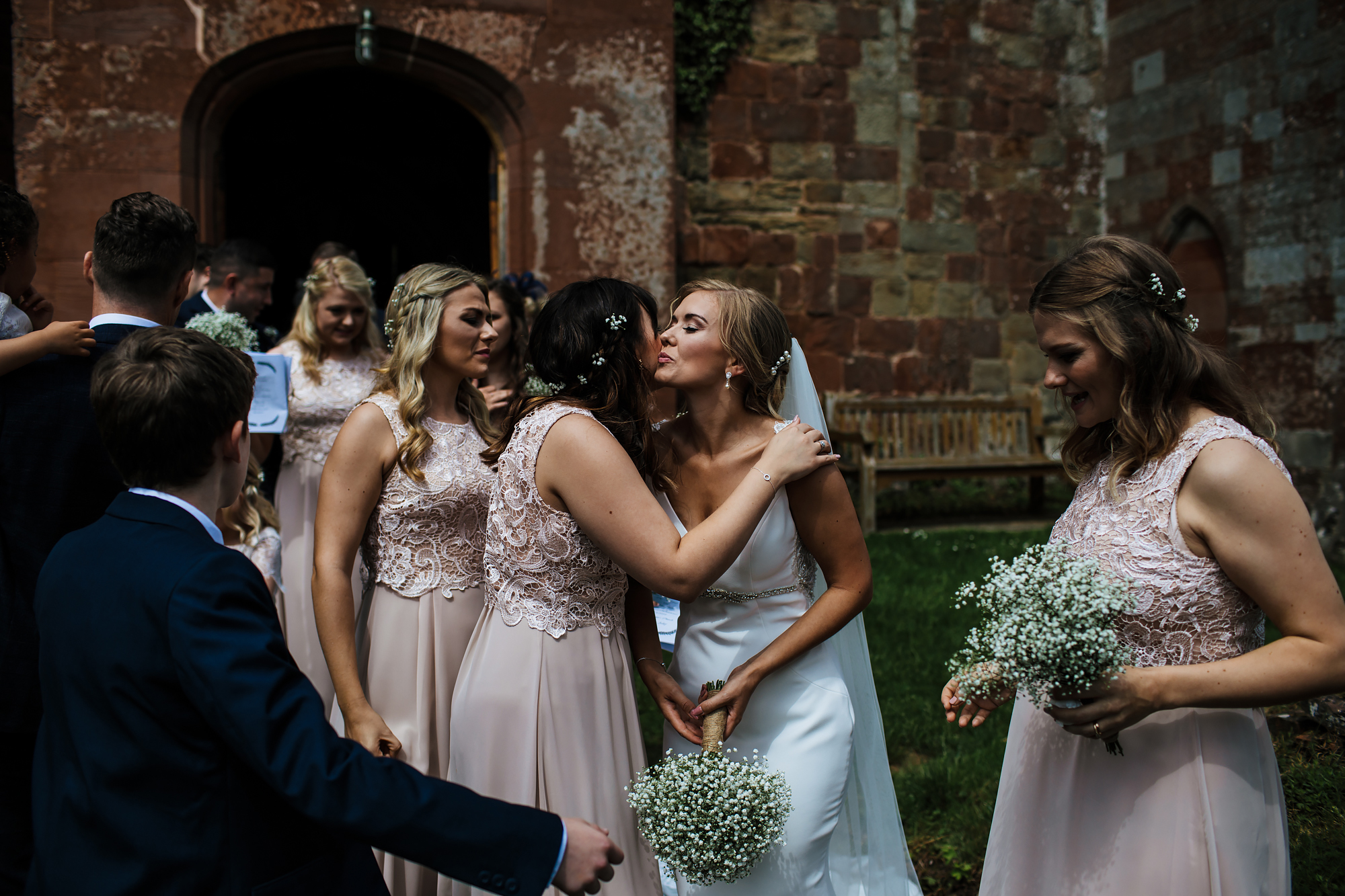 Bride kissing bridesmaid at a wedding in Shropshire