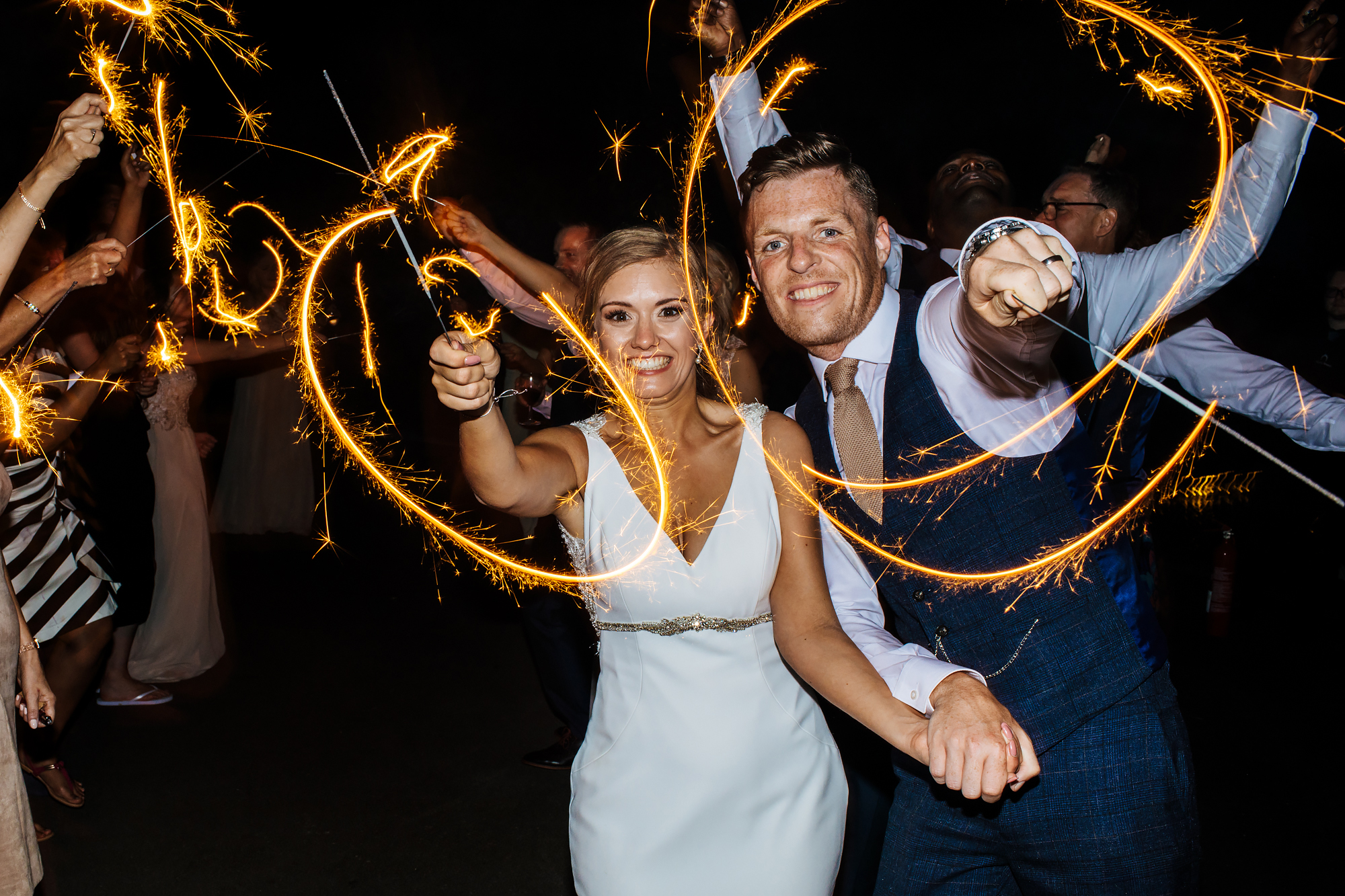 Bride and groom playing with sparklers at a wedding