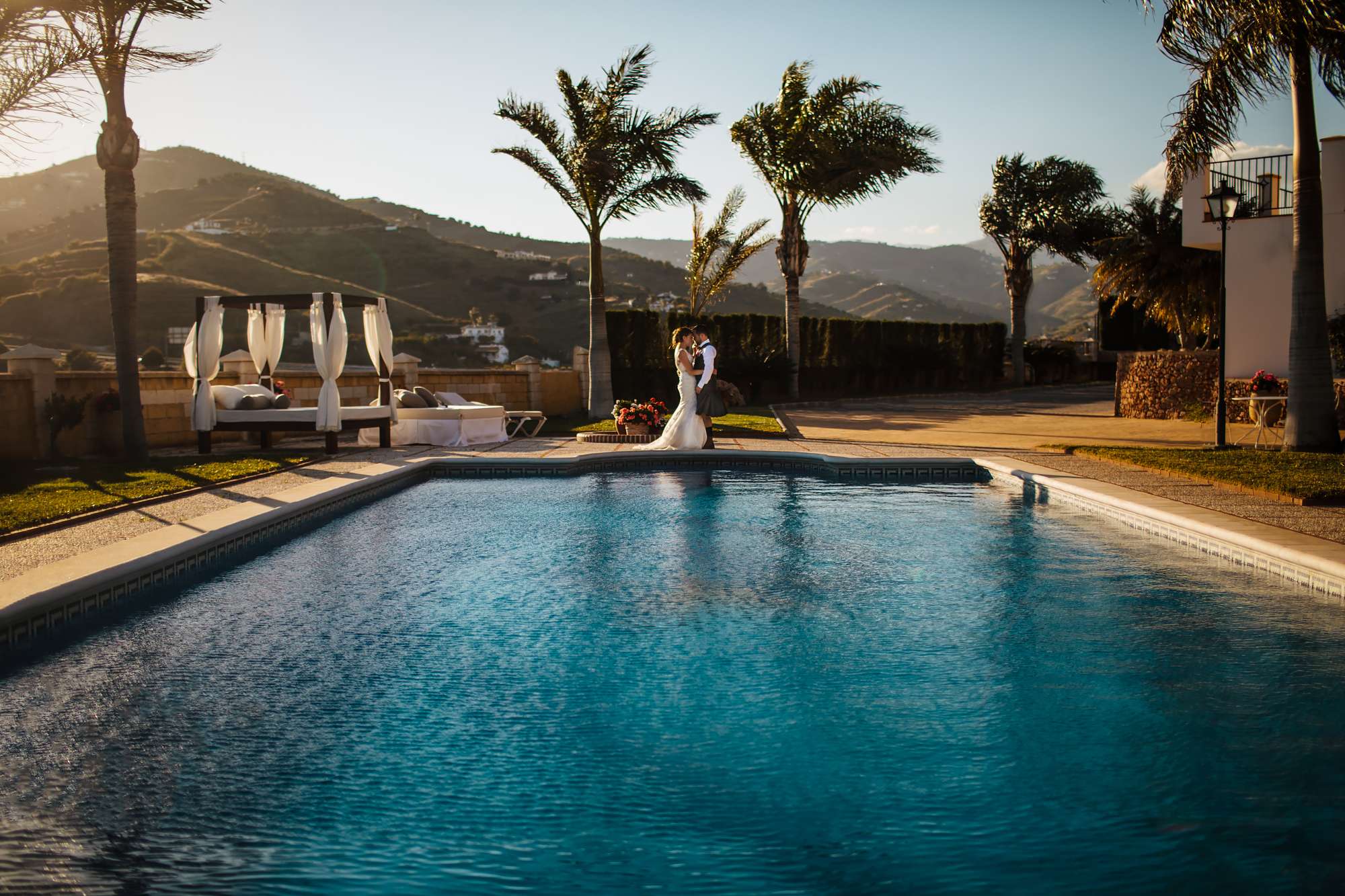 Bride and groom by the swimming pool at their wedding