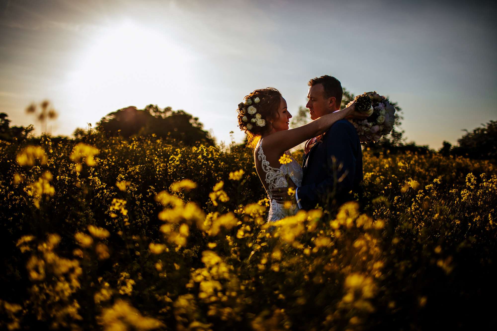 Rapeseed field at sunset with a bride and groom