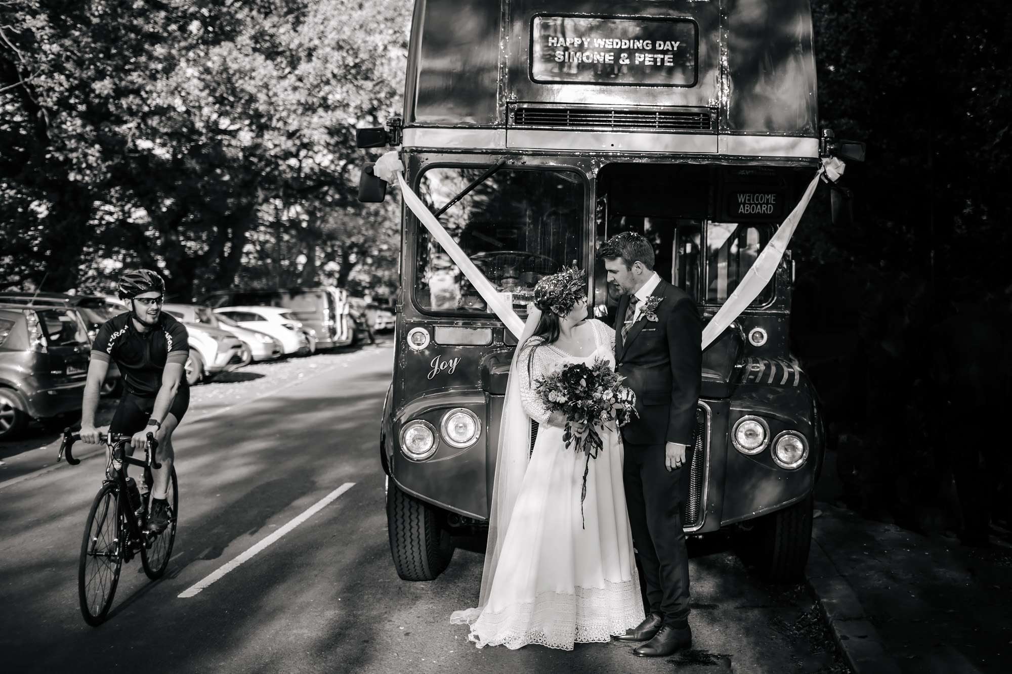 Bride and groom standing in front of their wedding bus in Leeds