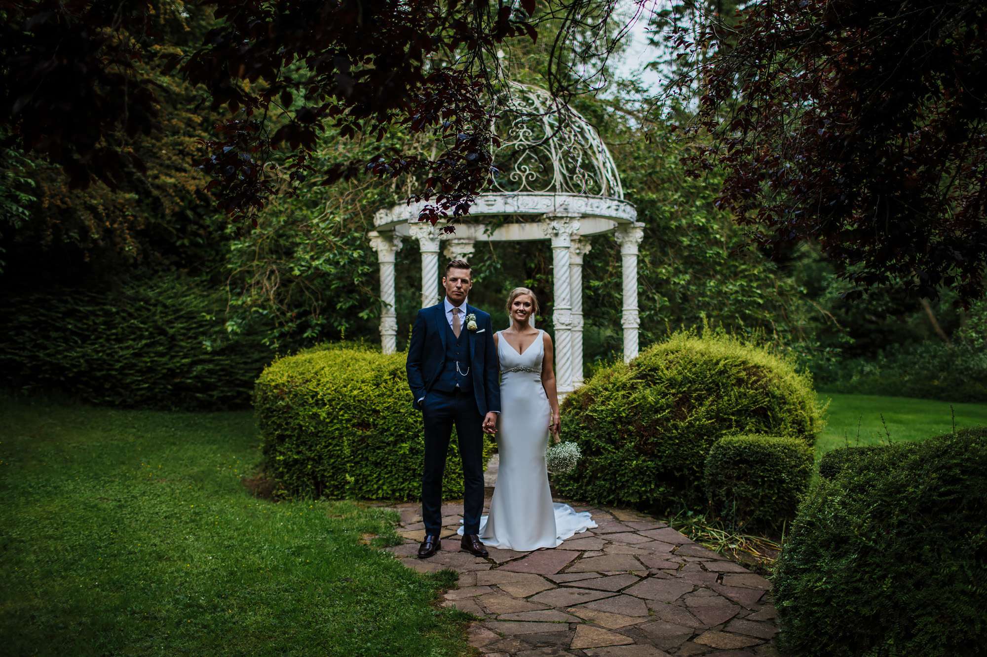 Bride and groom posing in front of a bandstand
