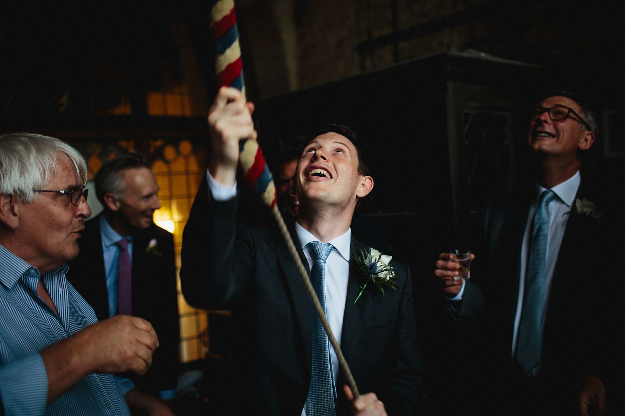 Groom ringing church bells at his wedding