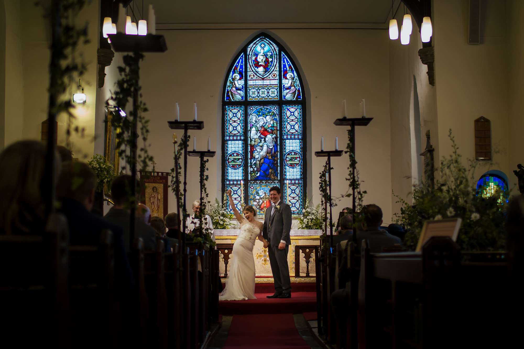 Bride celebrating by punching the air at a church wedding ceremony