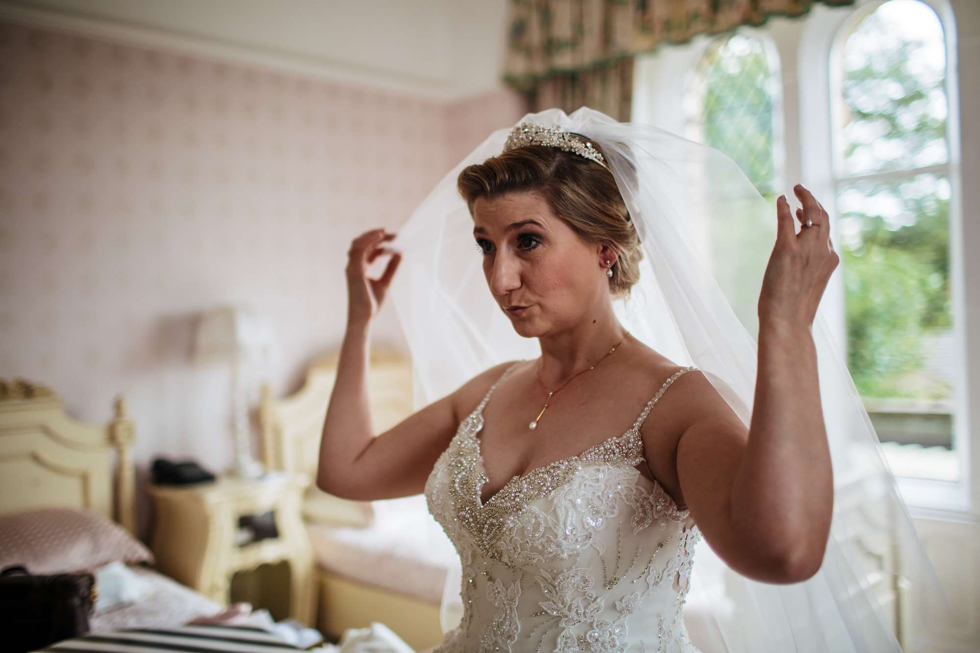 Bride adjusting her veil before her wedding