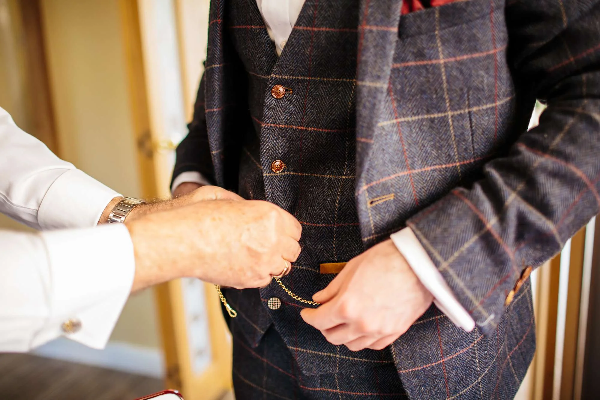 Groom attaching his pocket watch