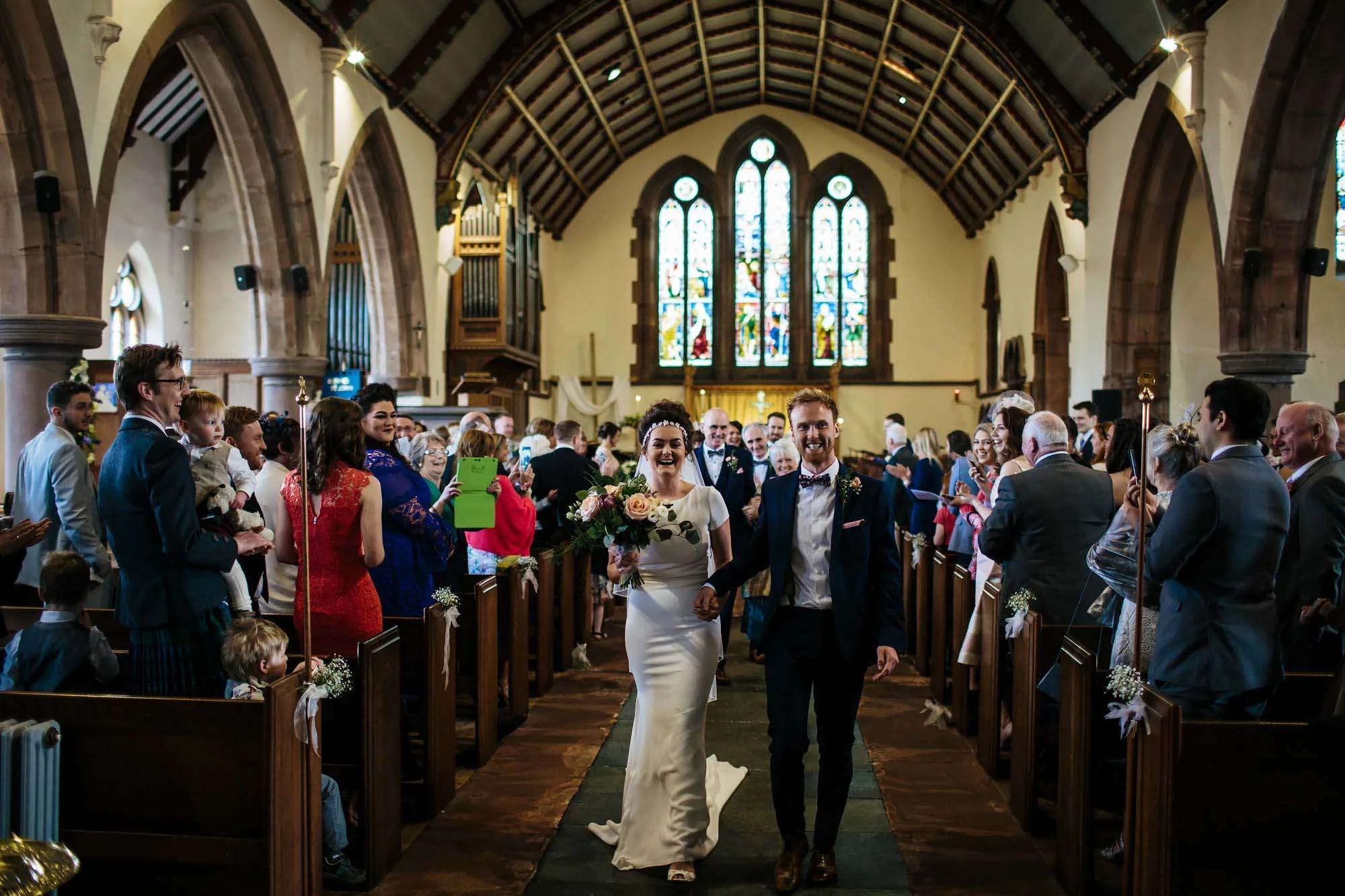 Happy bride and groom walking down the aisle