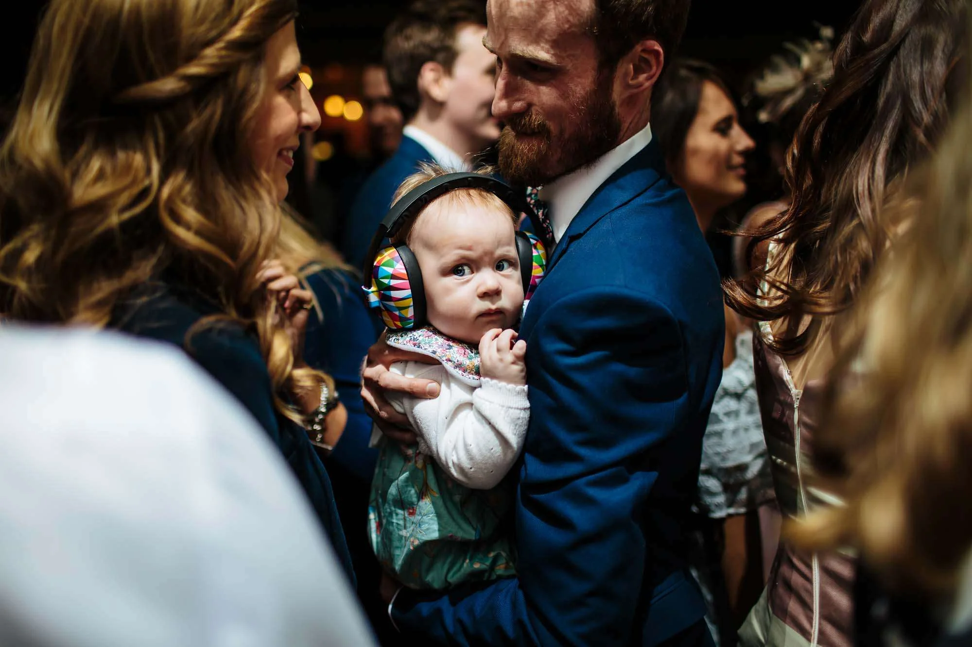 Young baby with ear defenders at a wedding