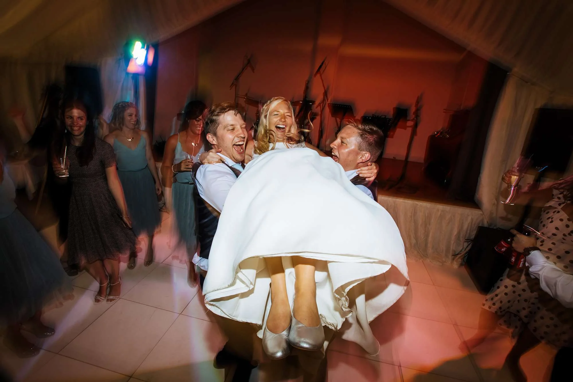 Bride being lifted on the dance floor at East Keswick Village Hall