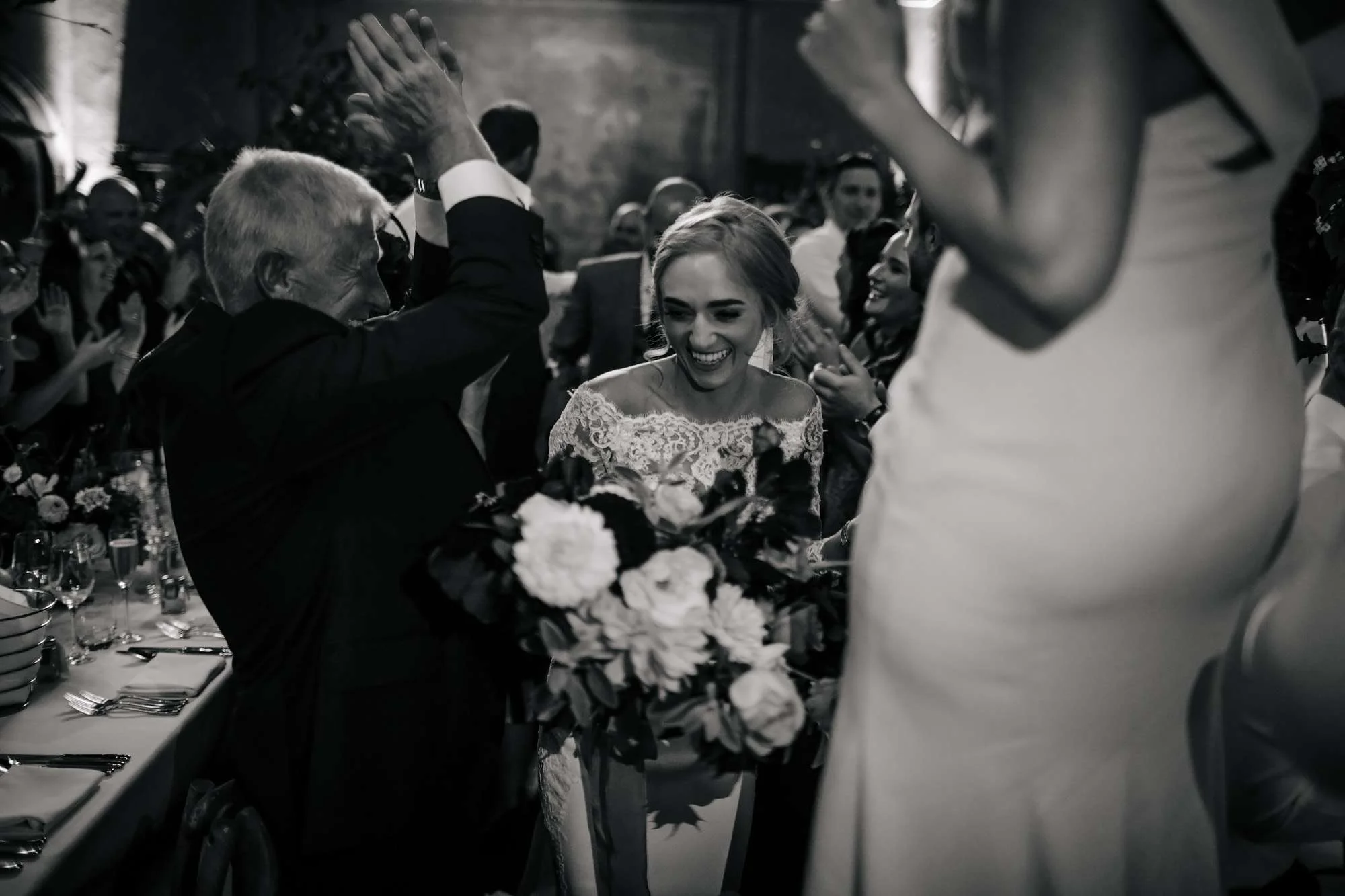 Guests cheer as bride and groom enter the dining room