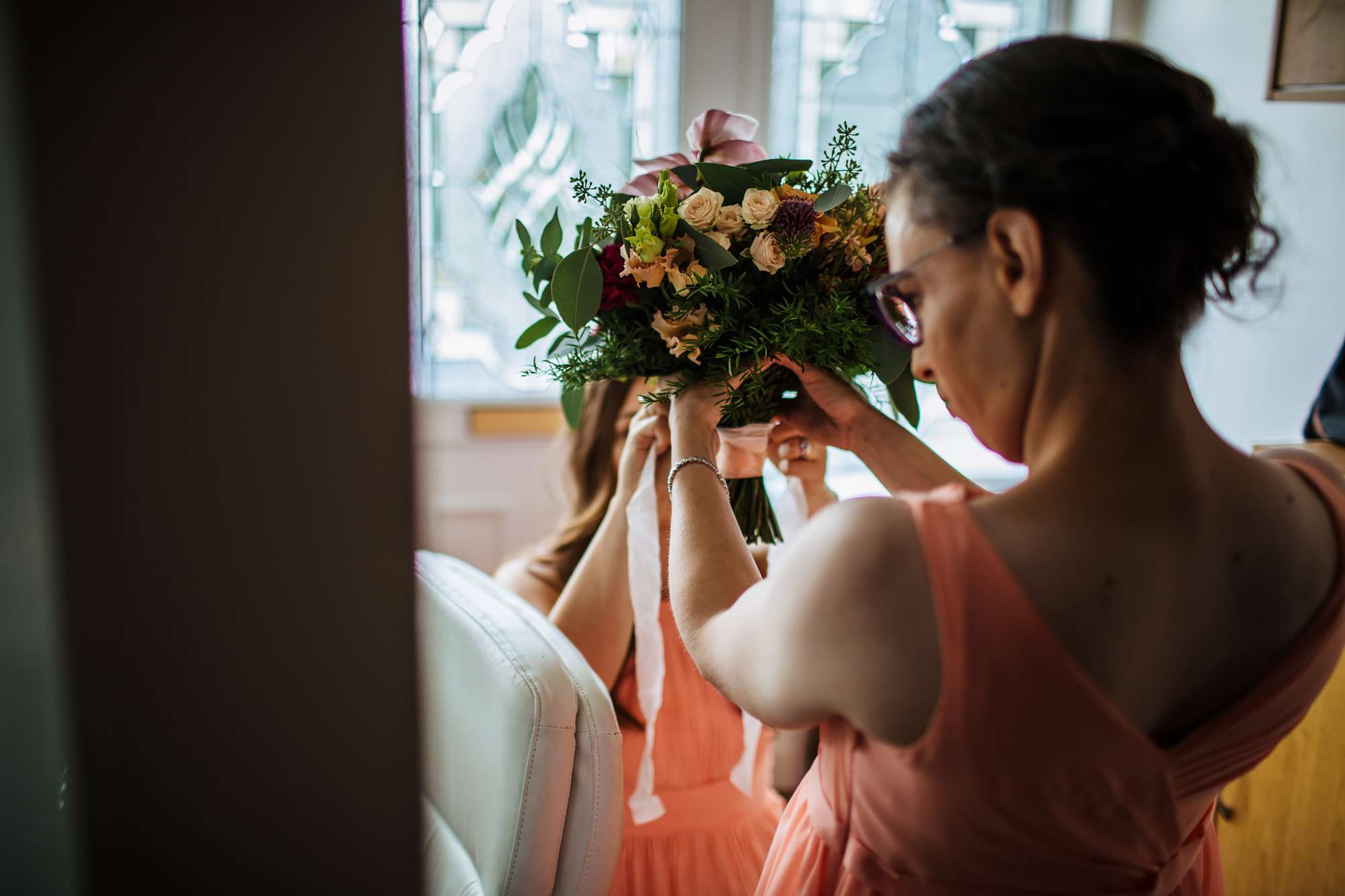 Bridesmaid holding the bride's bouquet at a wedding