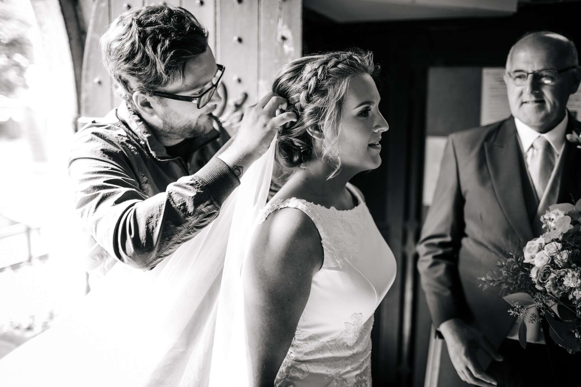 Bride having her veil attached in the church