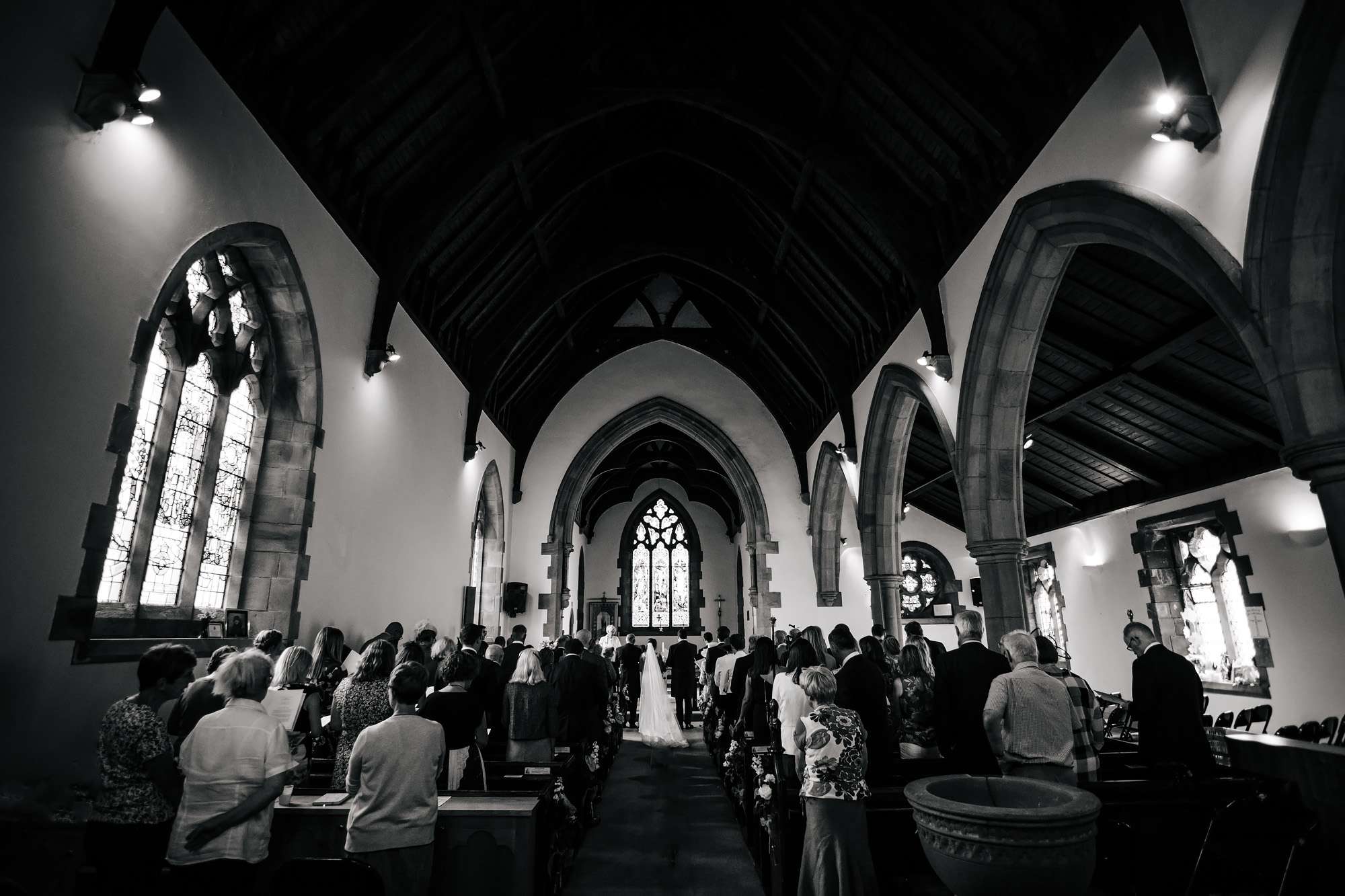 Black and white wide shot of the church interior of a wedding
