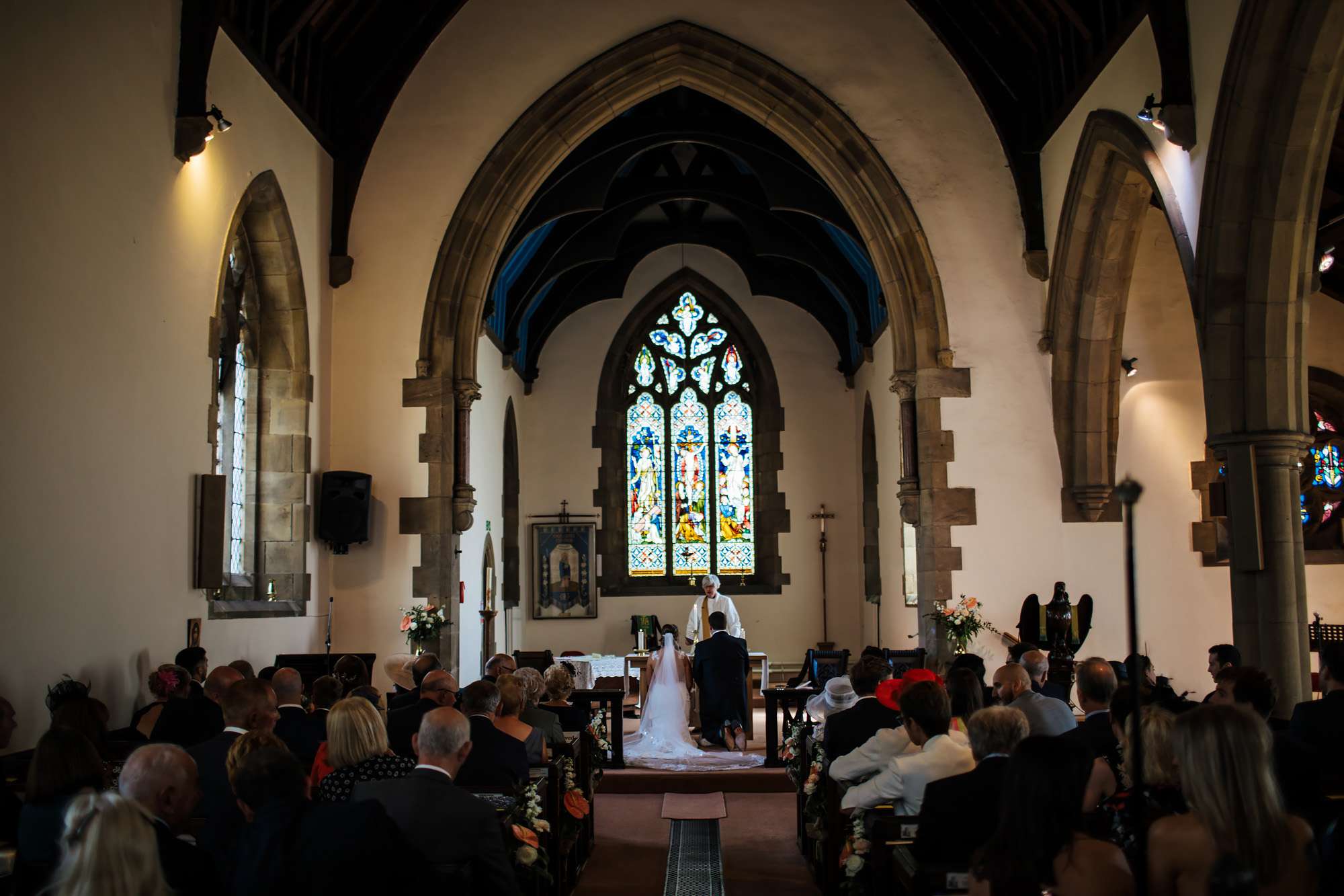 Bride and groom kneeling to pray at their wedding ceremony