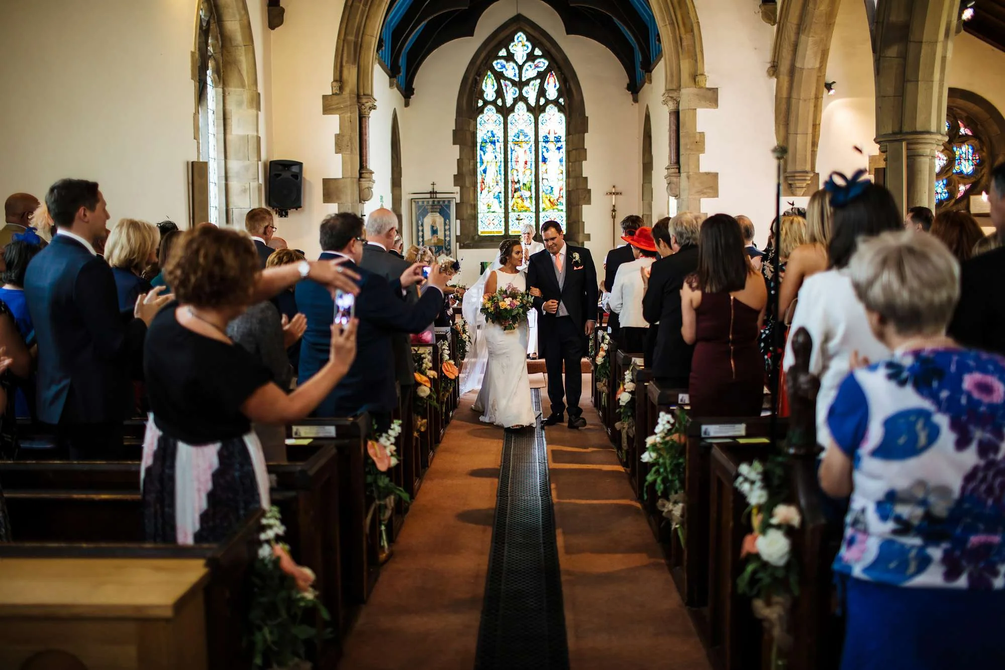 Newlyweds walking down the church aisle in Huddersfield