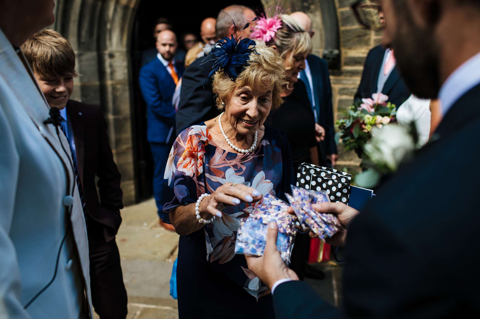 Wedding guest taking confetti in the sunshine