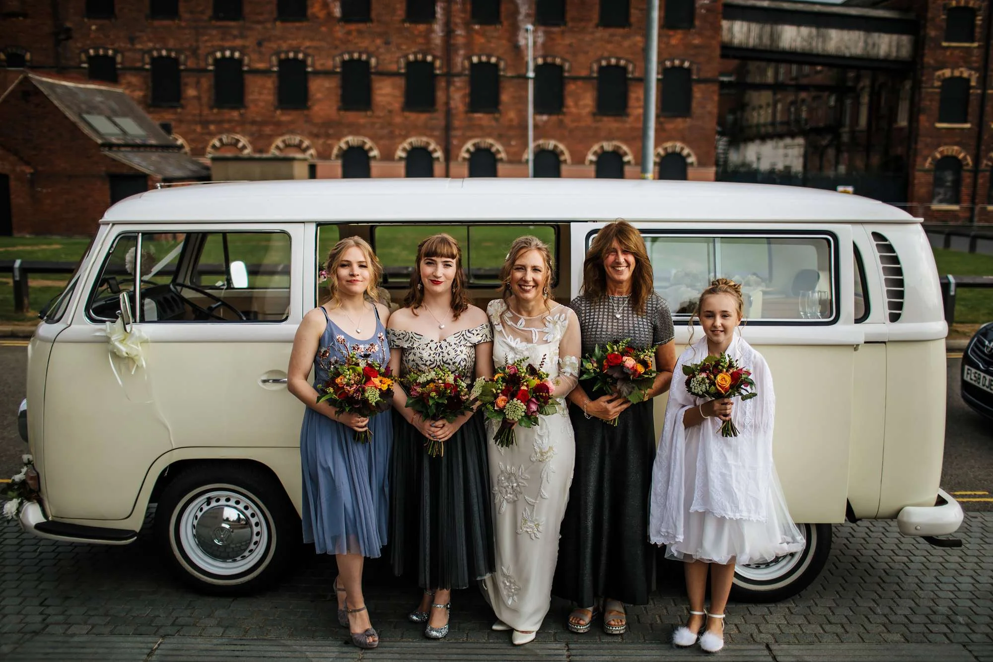 Bridal party posing in front of a VW campervan
