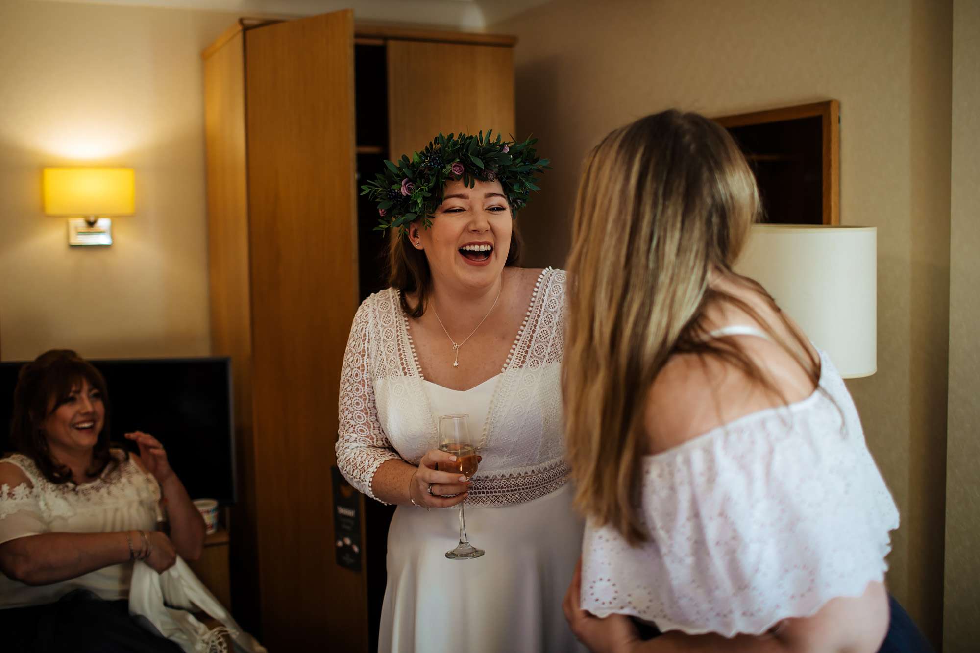 Bride laughing with her bridesmaid before her wedding