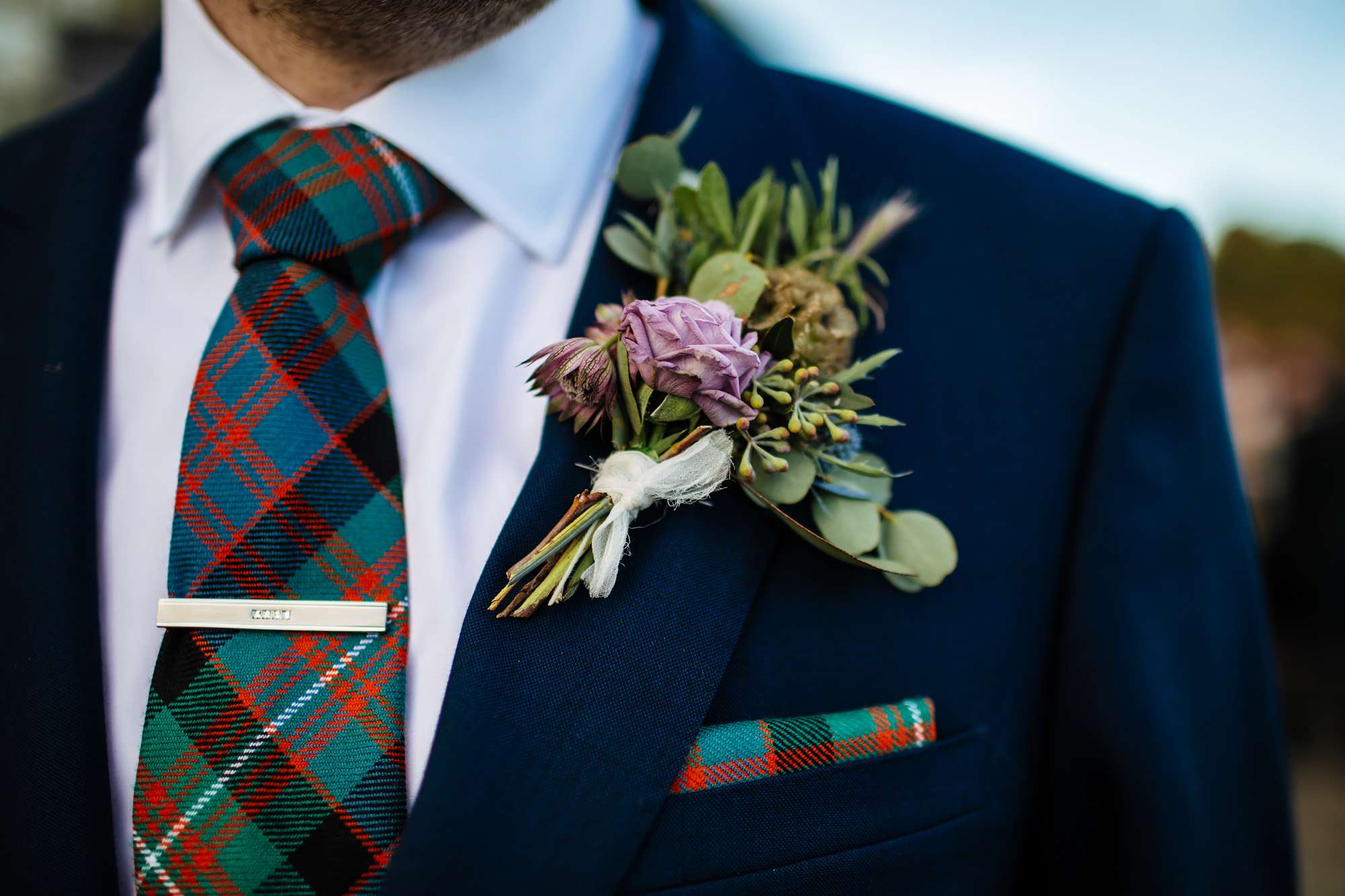 Close up of the groom's tartan tie and buttonhole