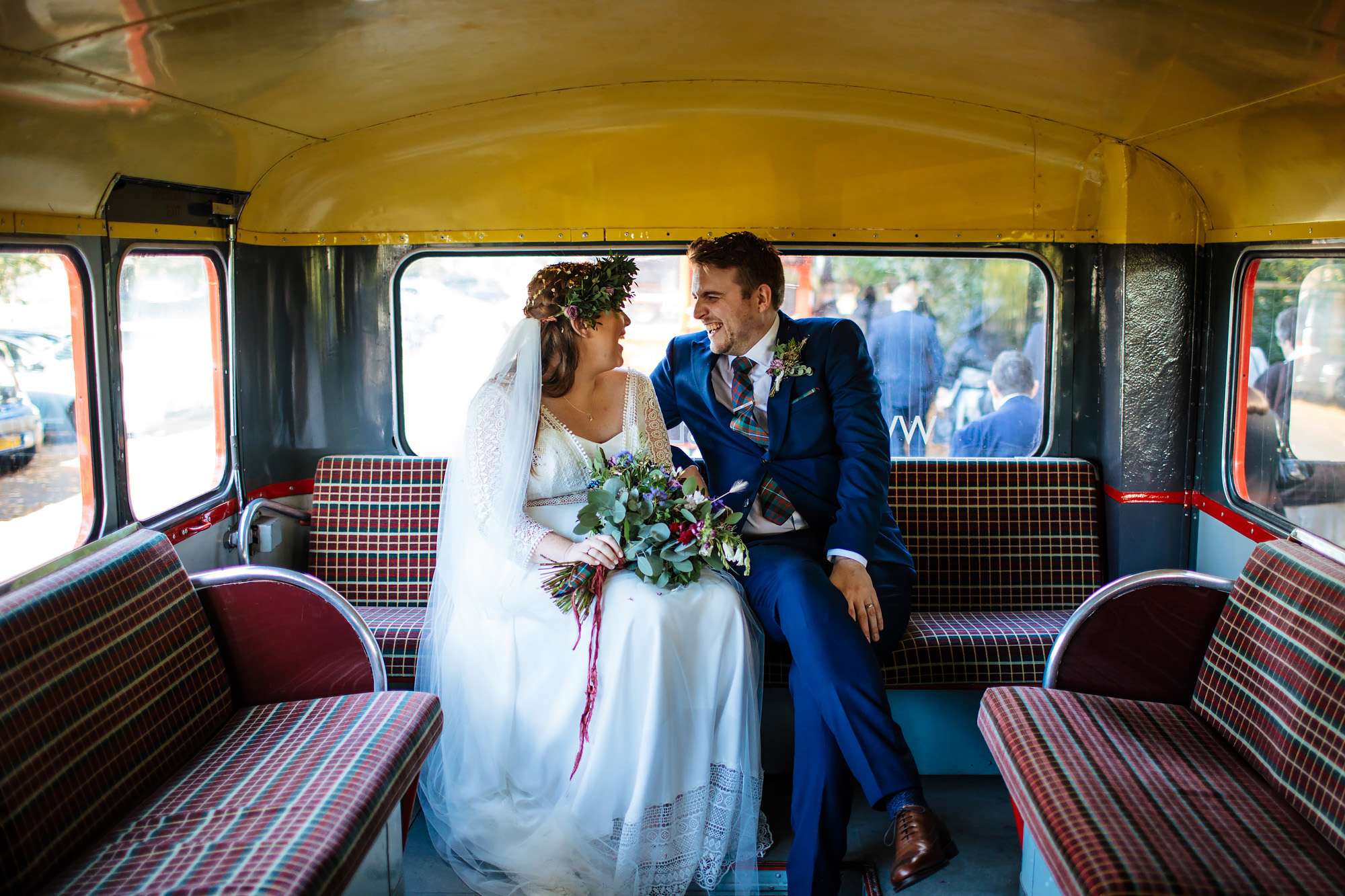 Bride and groom sitting on their vintage bus at a wedding