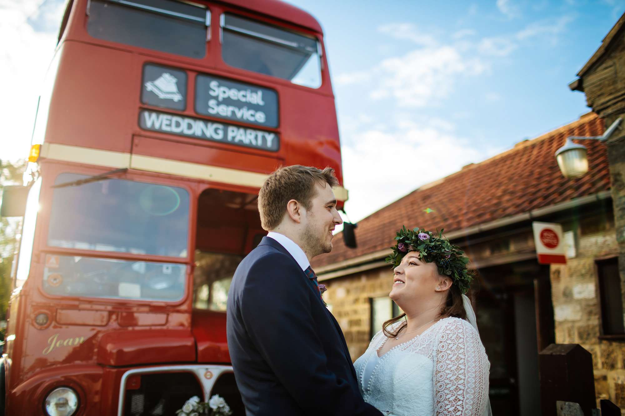 Bride and groom portrait with their bus in the background
