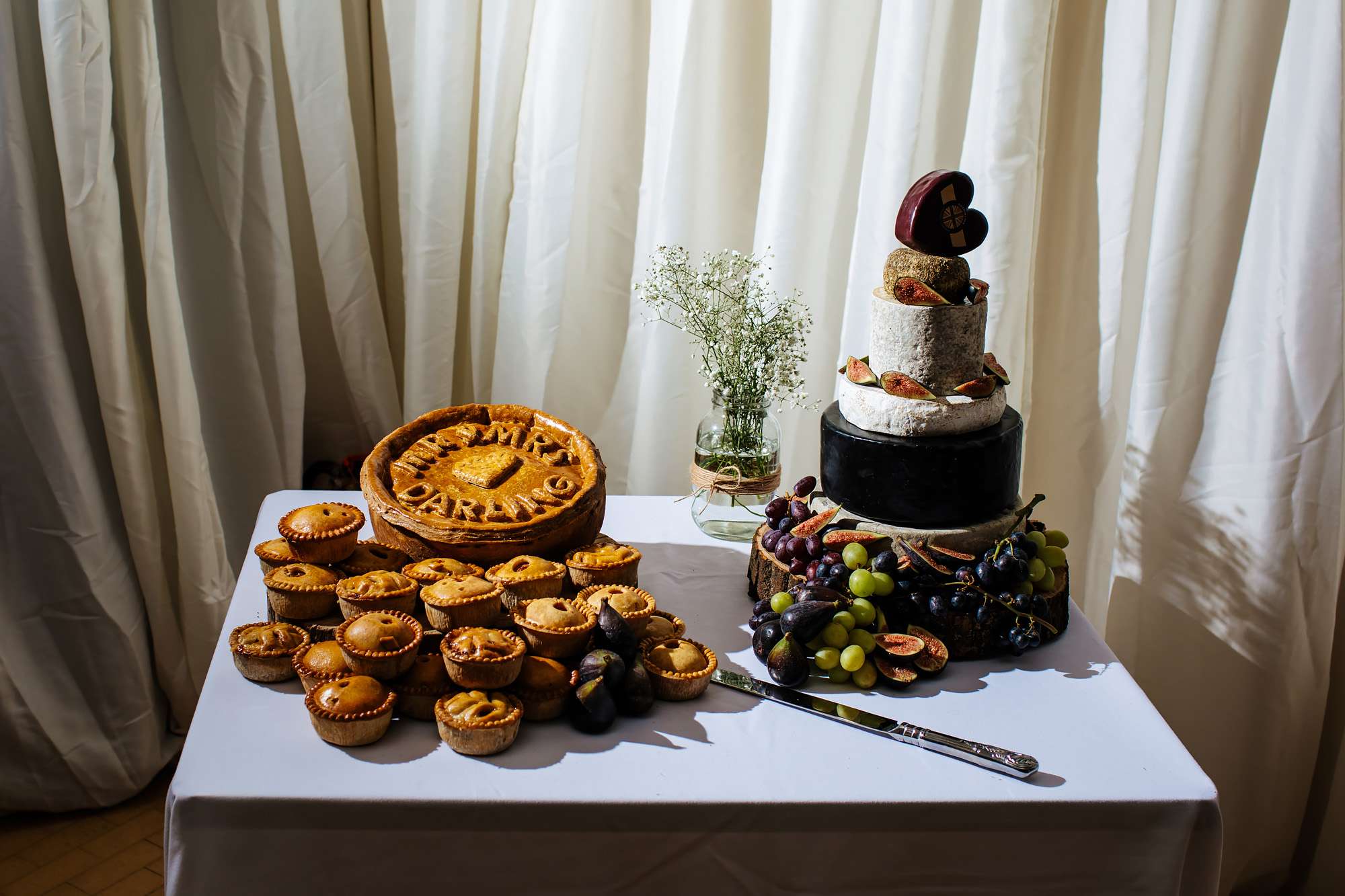 Close up of the wedding cake and pork pie cake at a wedding
