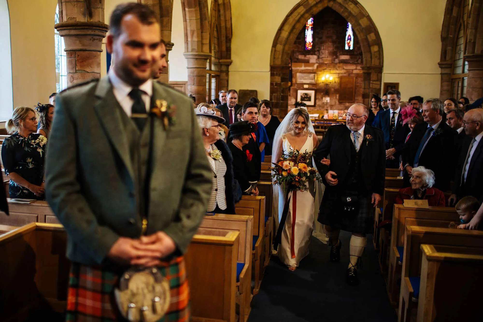 Bride and dad walk down the aisle to meet the groom