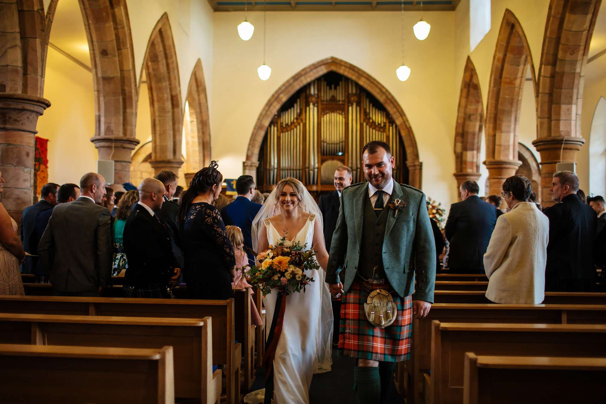 Bride and groom walk down the aisle at their wedding