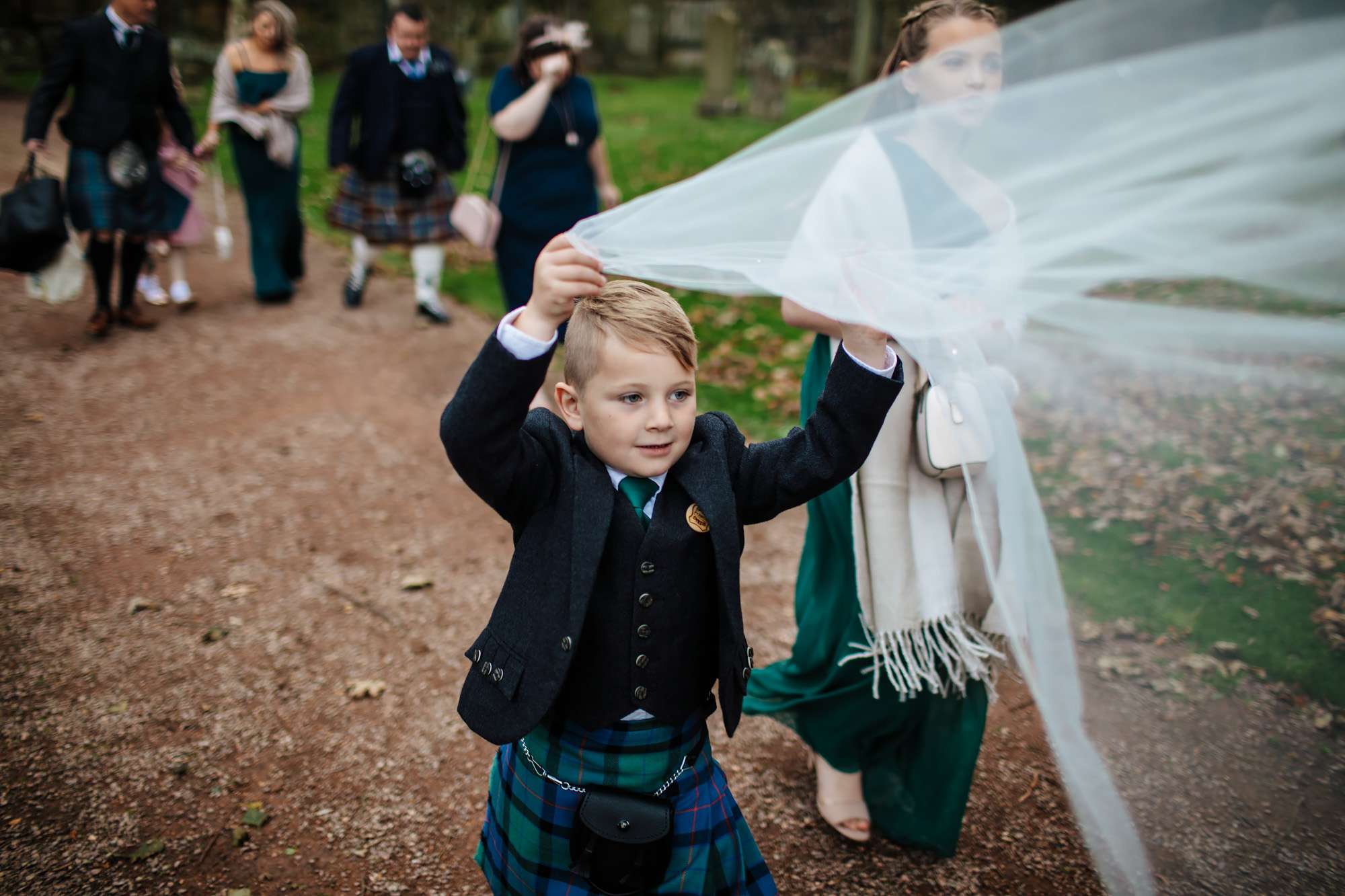 Bride's son playing with her wedding veil