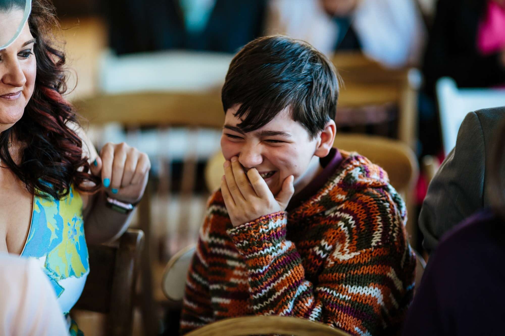 Young boy laughing at a wedding