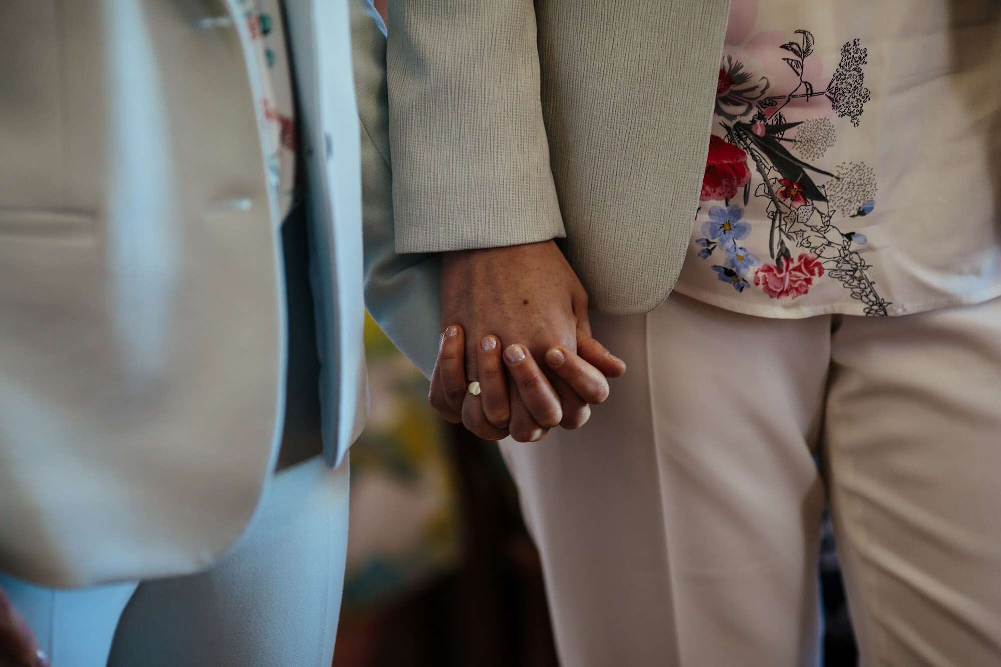Two brides holding hands during a gay wedding ceremony