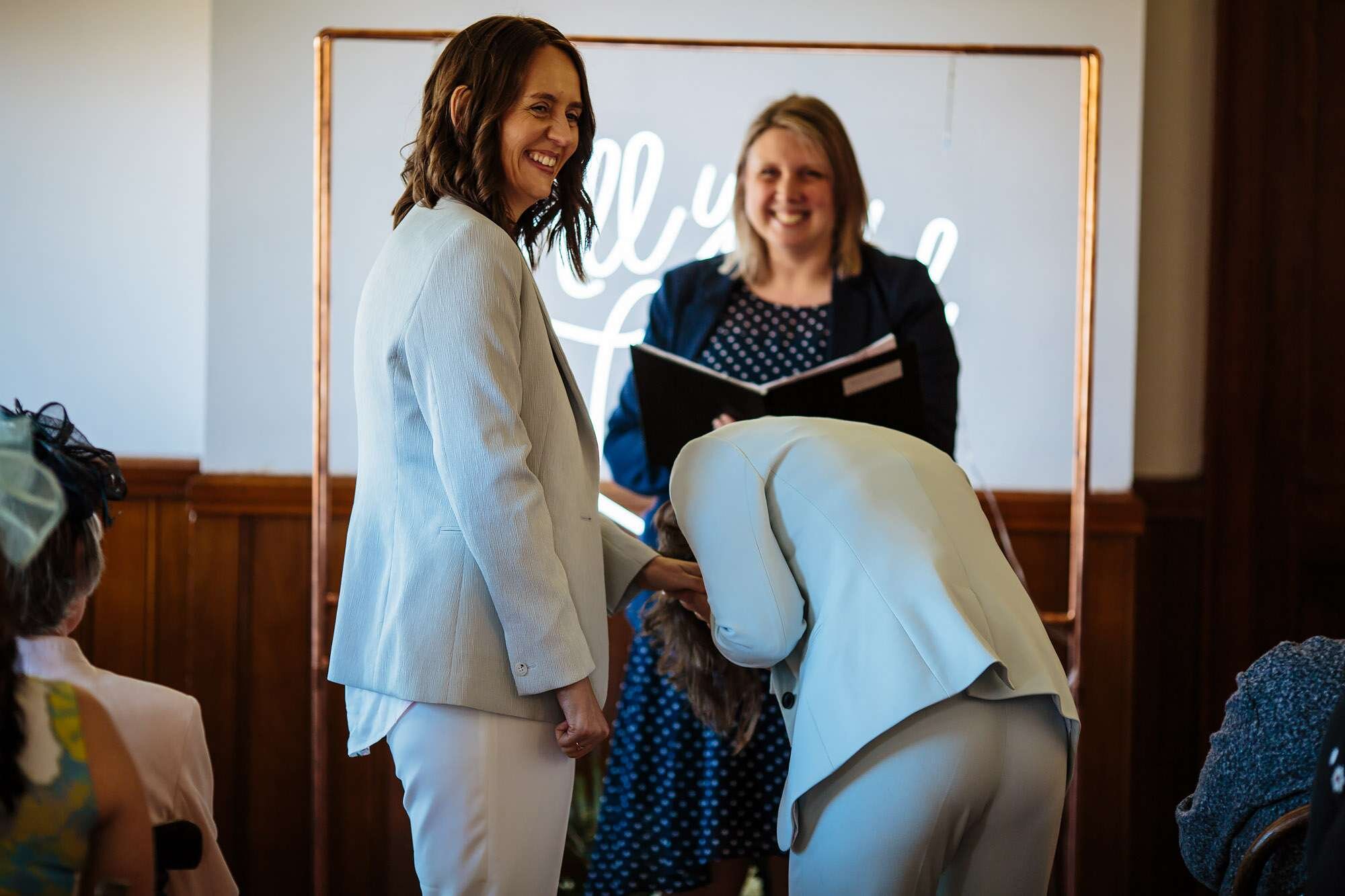 Brides laughing during their gay wedding ceremony
