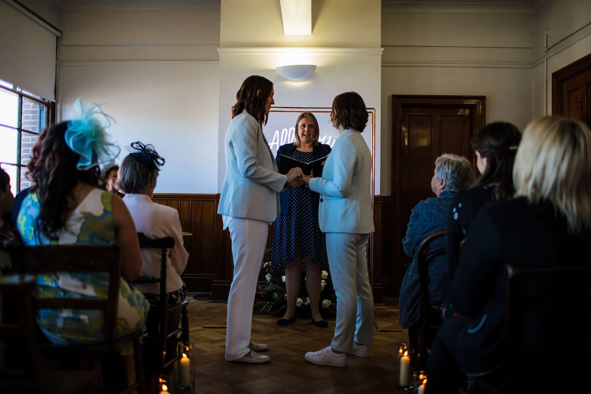 Two brides holding hands at their wedding