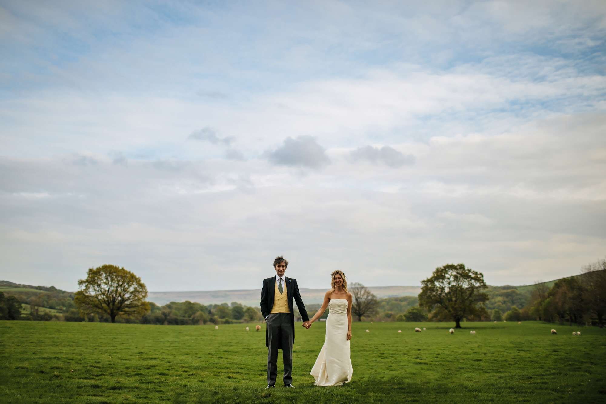 Bride and groom posing in a Yorkshire sheep field