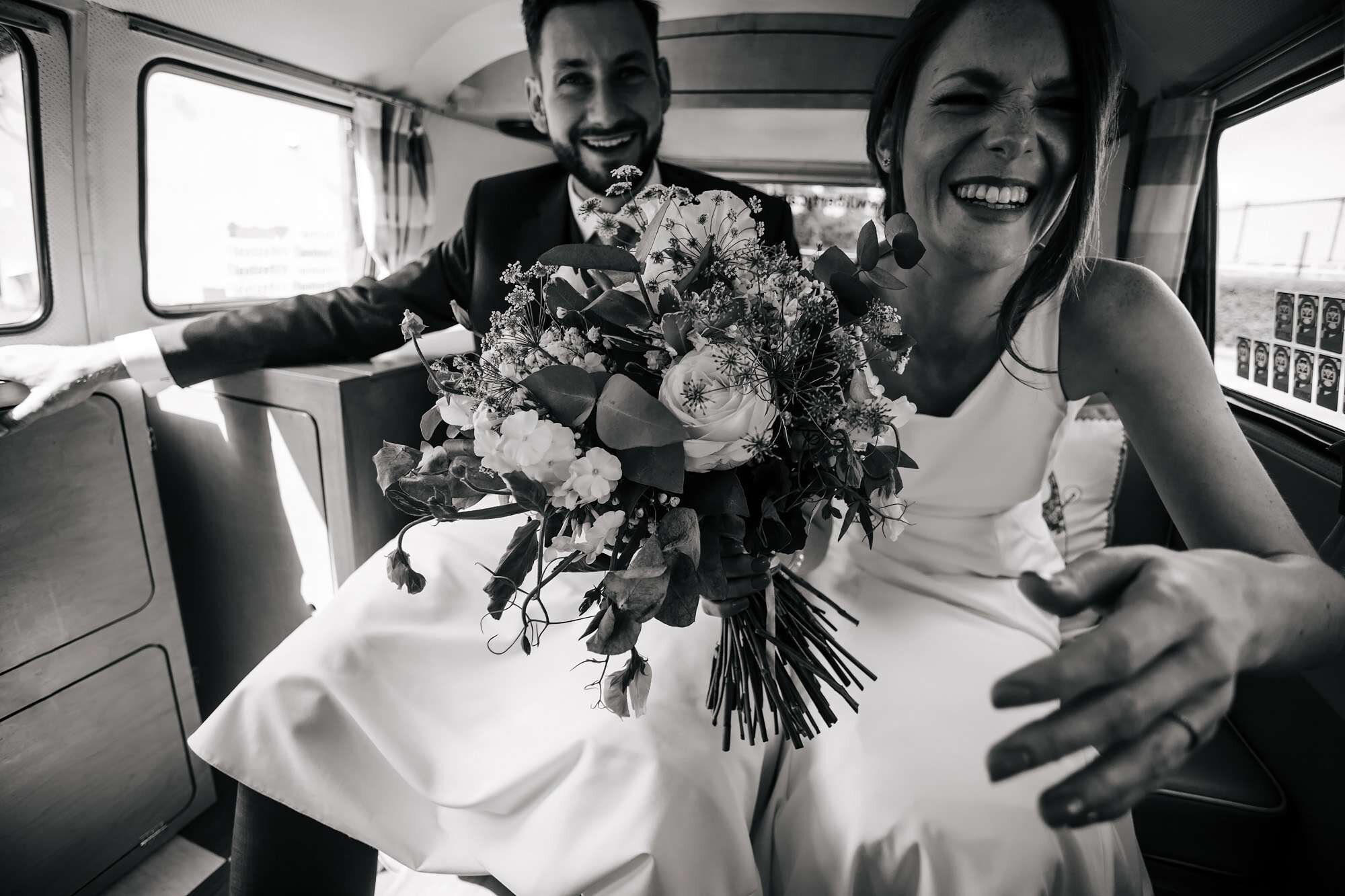 Bride and groom in a camper van on their wedding day