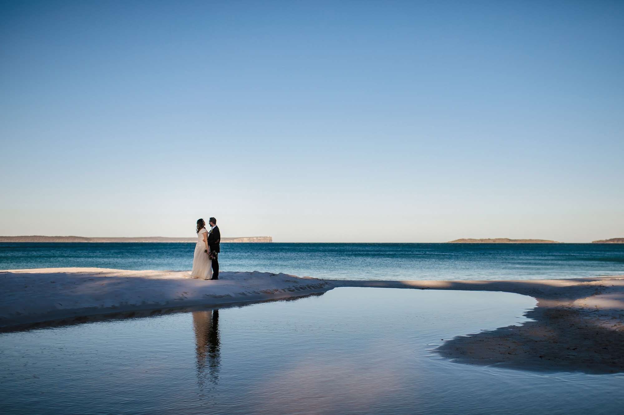 Bride and groom posing on the beach in Australia