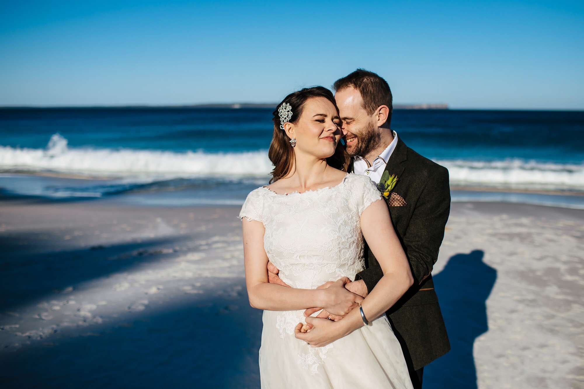 Bride and groom share a moment on the beach at their wedding