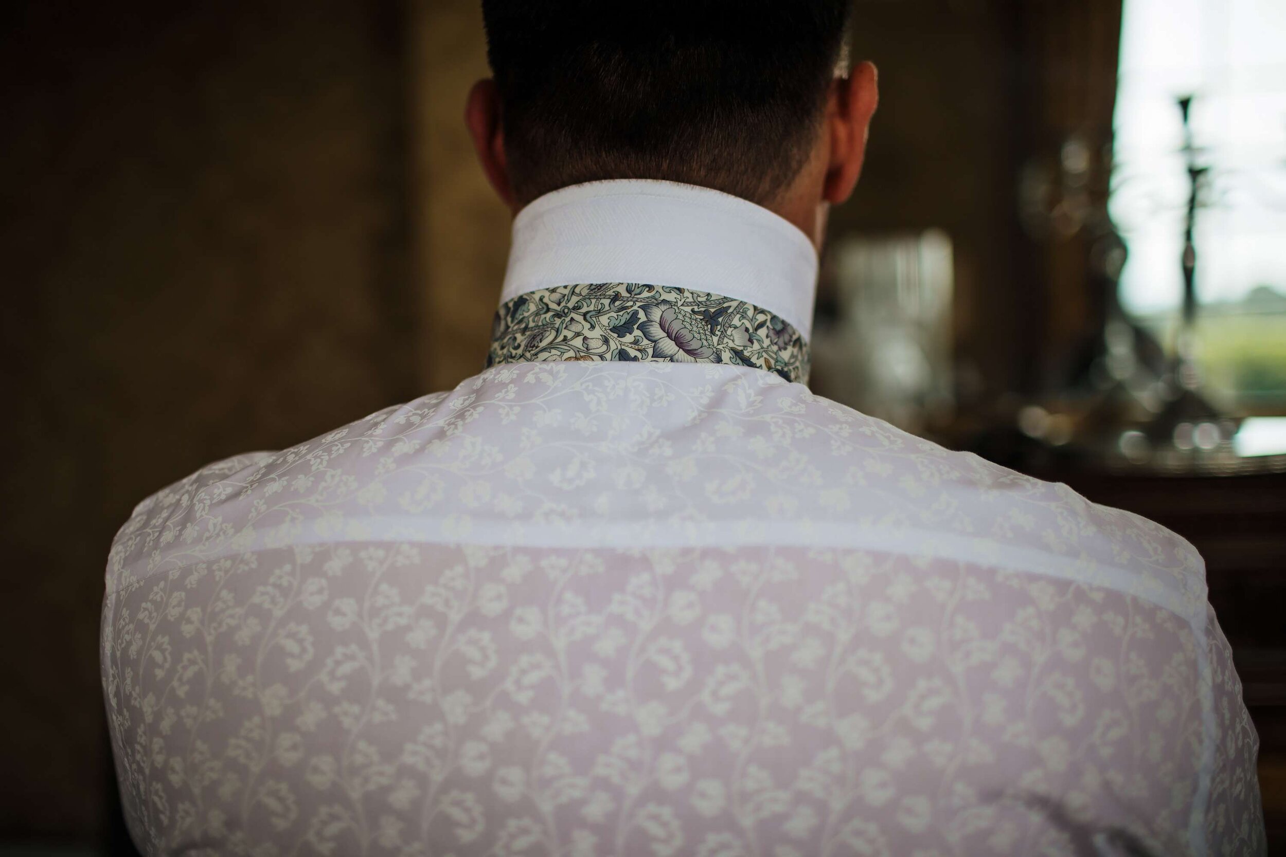 Close up of the groom's patterned shirt at his wedding