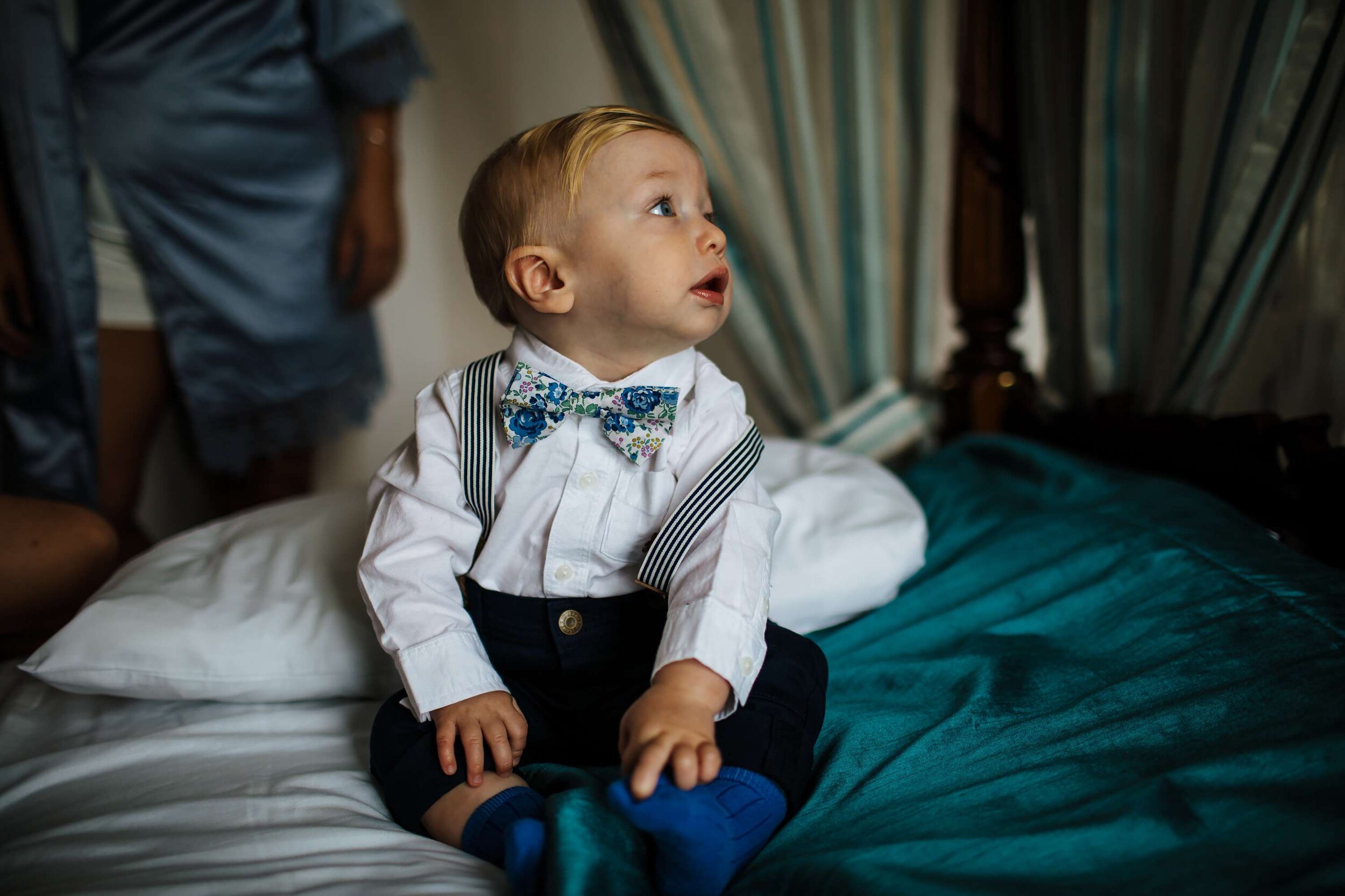 Young boy posing on the bed before his mum's wedding in Yorkshire