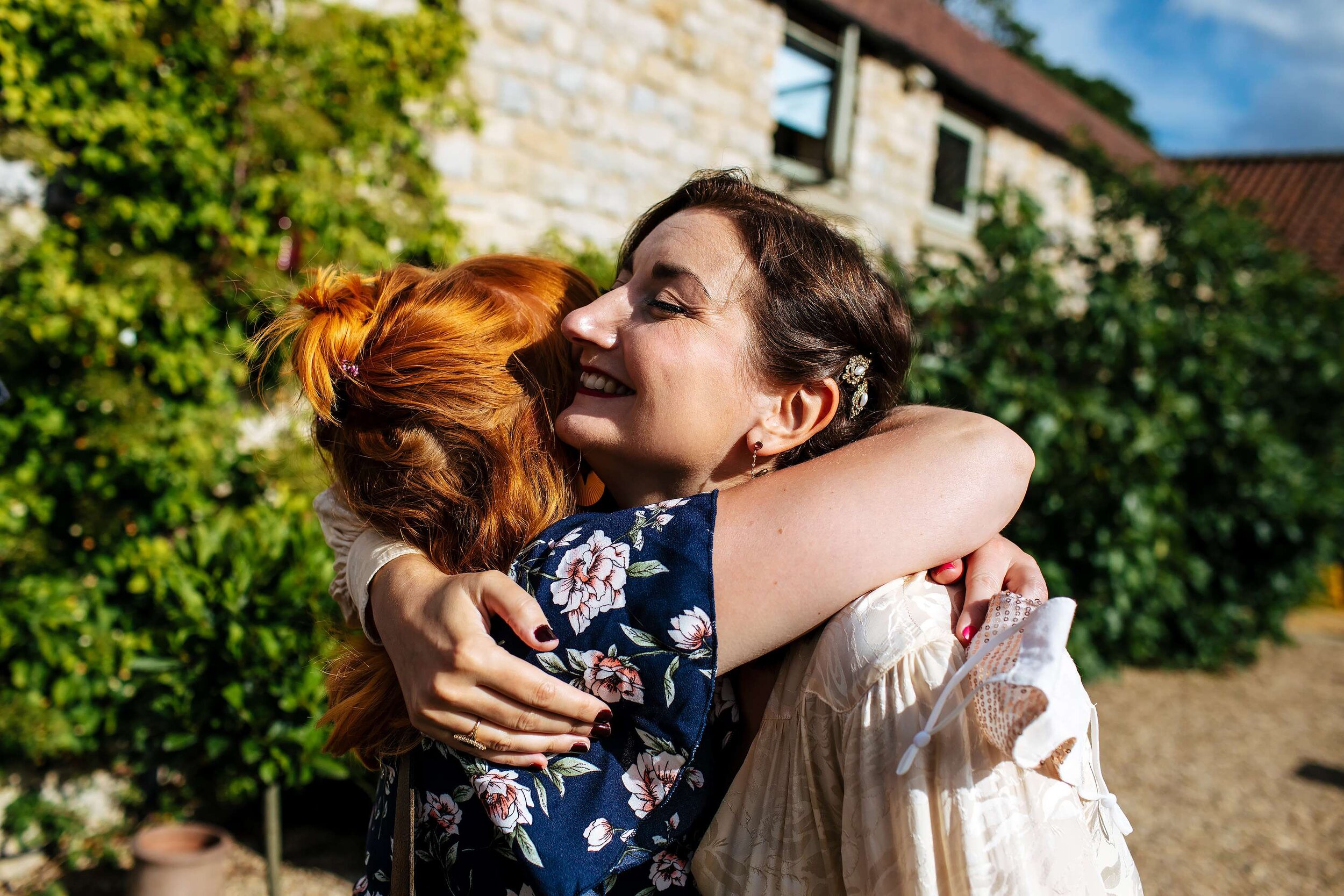 Bride and bridesmaid hugging at a Yorkshire wedding
