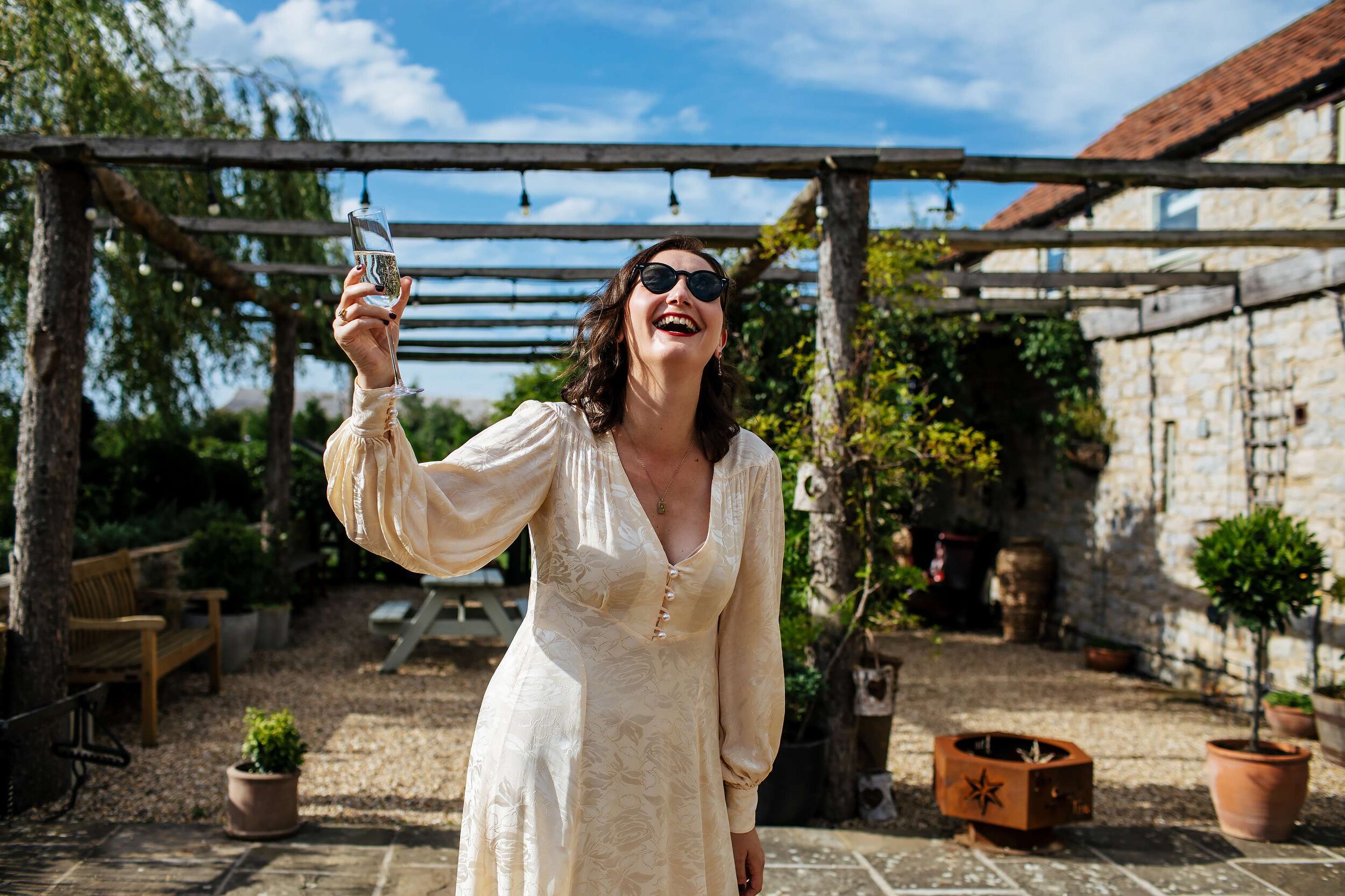 Bride laughing with a glass of champagne at her wedding