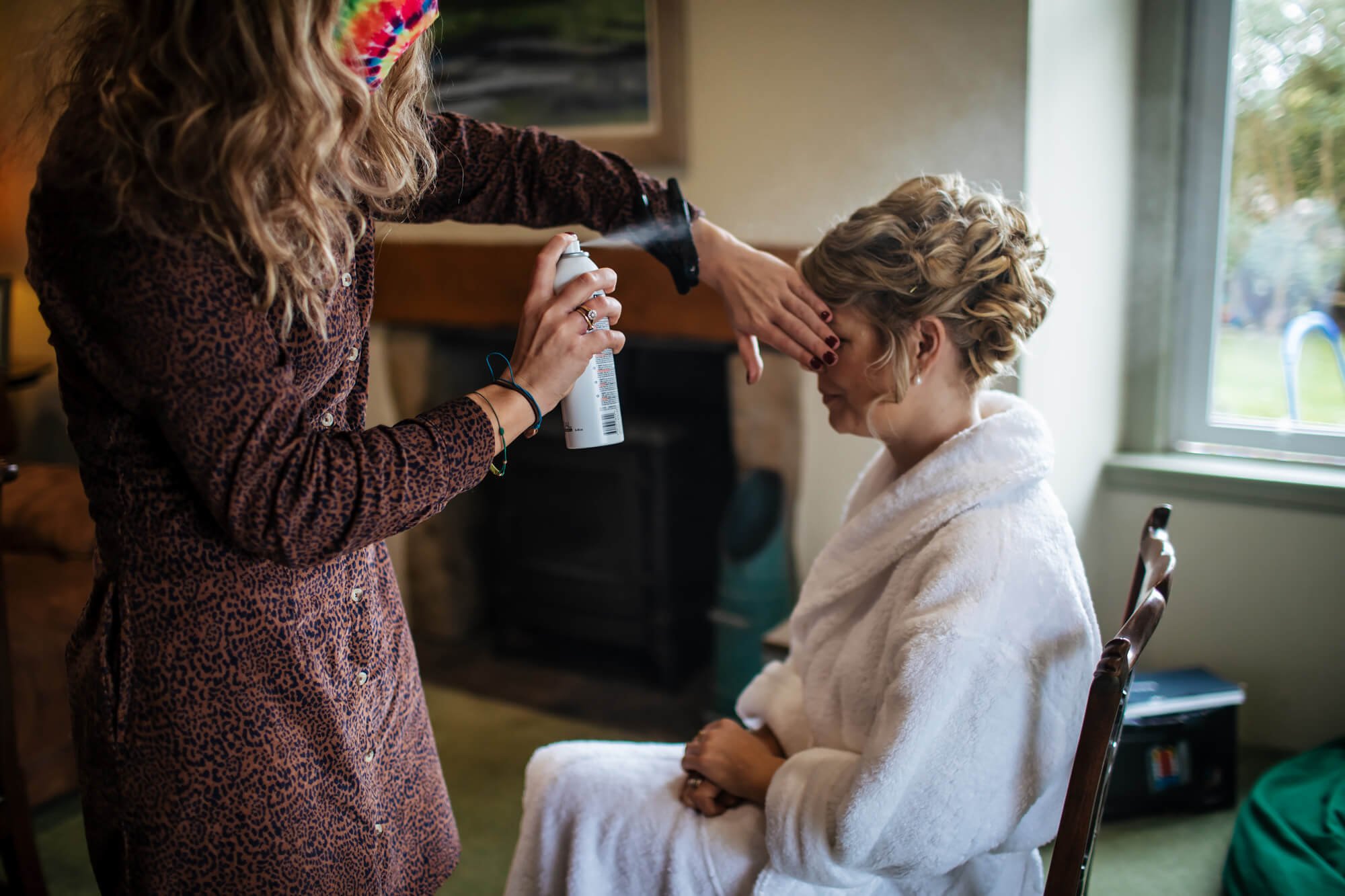 Bride having her hair sprayed for a wedding