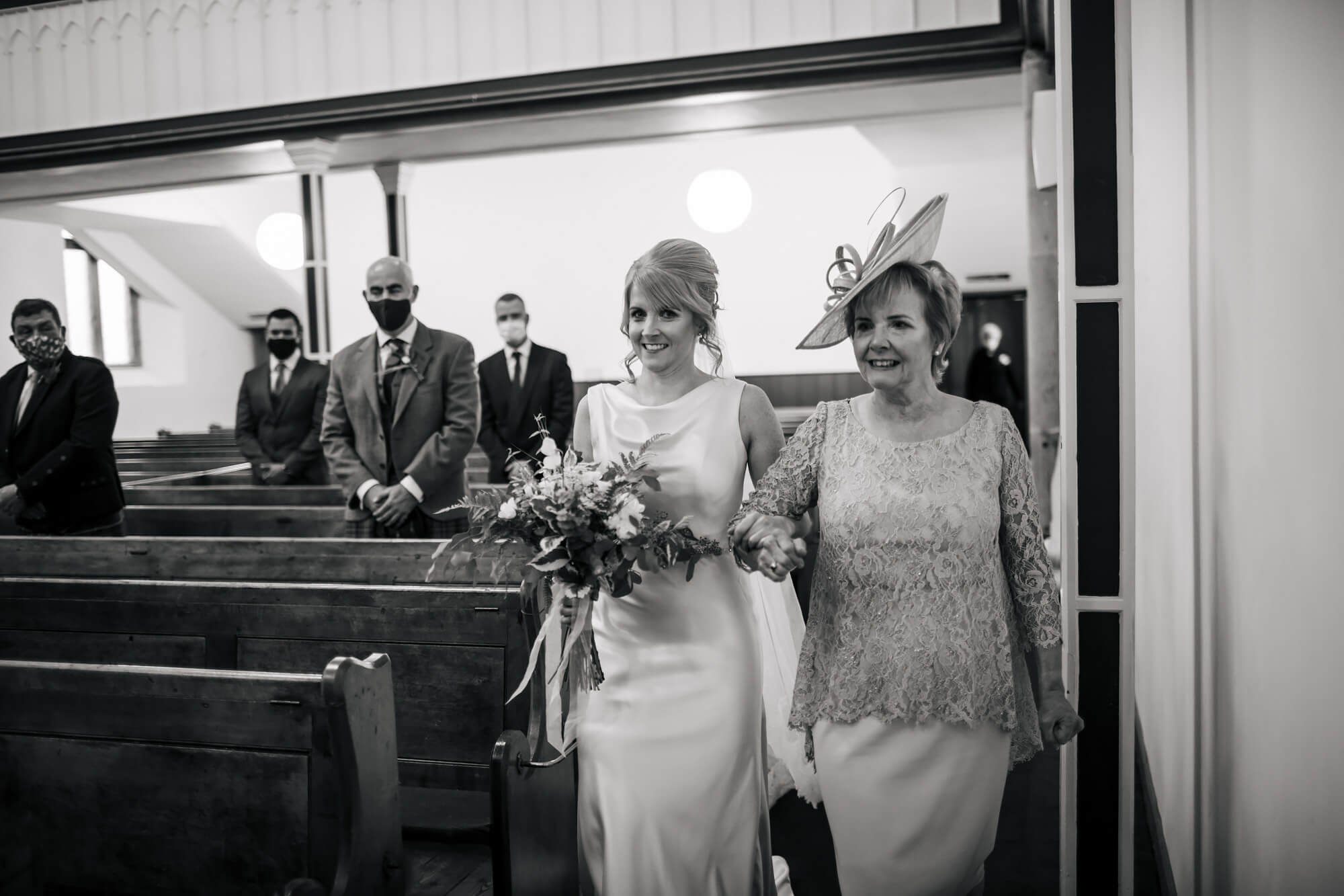 Bride and mum walk down the church aisle