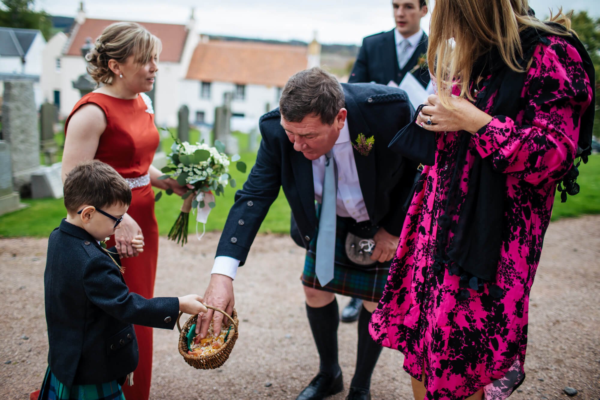 Young boy handing out confetti at a Scottish farm wedding